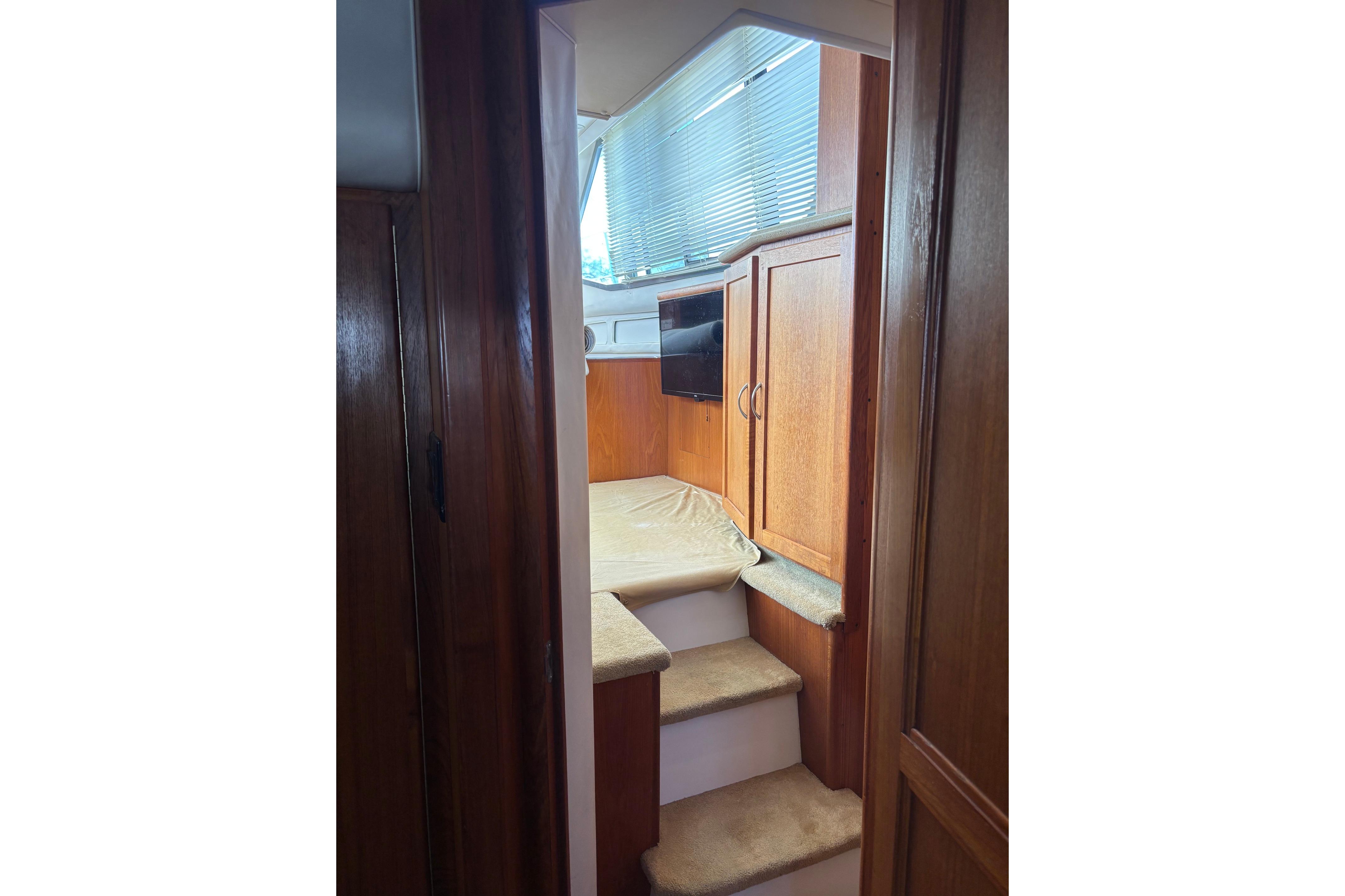 Interior of 1995 Carver 356 Aft Cabin Motor Yacht with wooden cabinetry and carpeted steps.