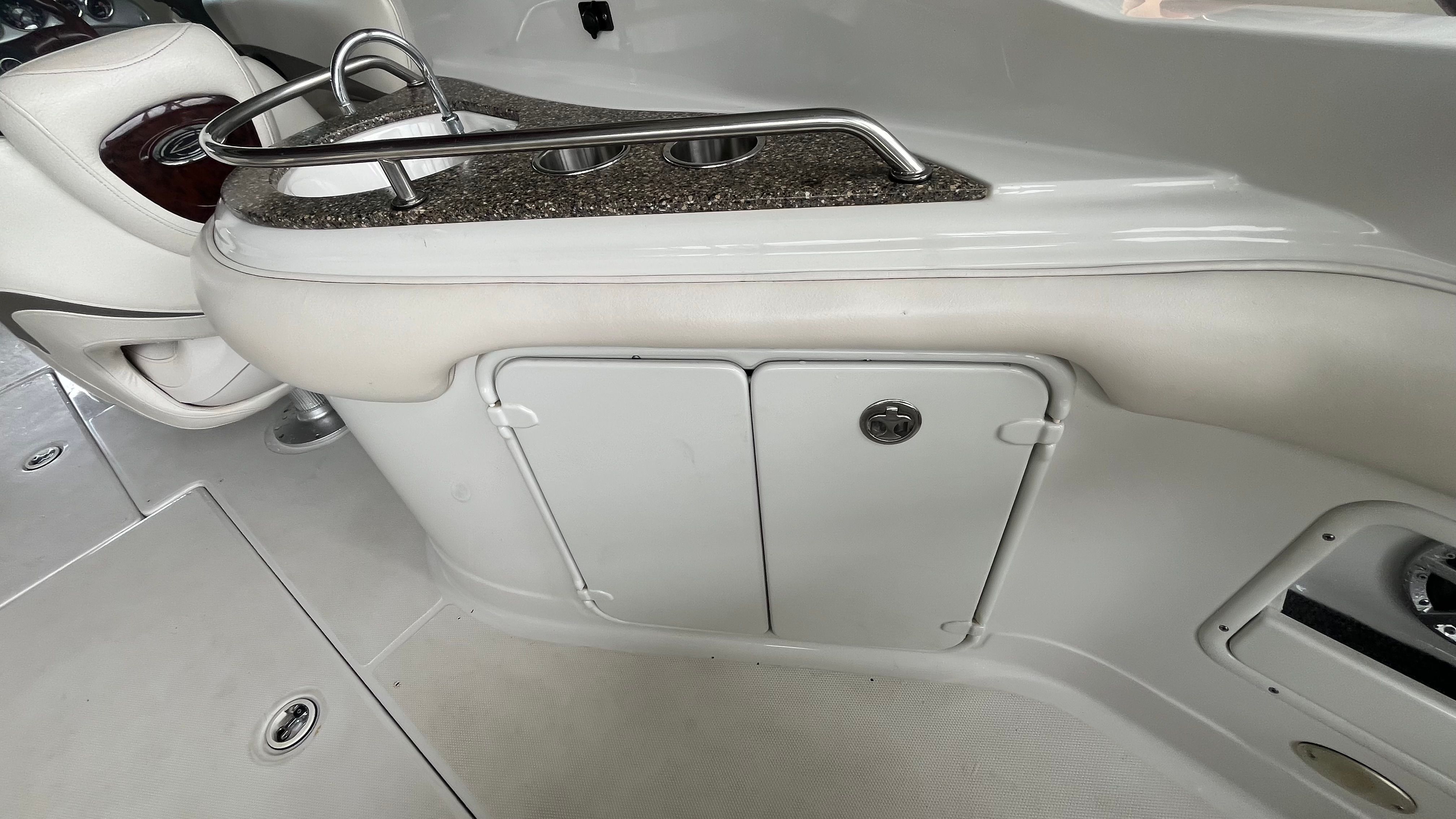 Interior view of a 2008 Crownline 252EX with a small kitchenette and storage space.