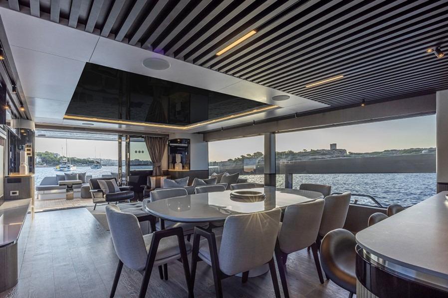 Luxurious interior of 2024 Pearl 82 yacht with elegant dining area and scenic ocean view.