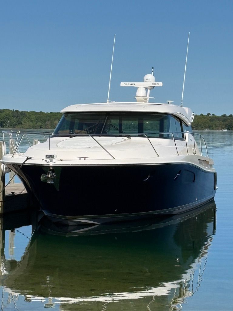 A 2017 Tiara Yachts C44 Coupe is docked calmly by the pier.