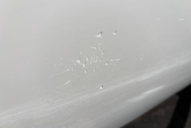 Close-up of paint imperfections on a 2024 Tahoe T21 vehicle surface.