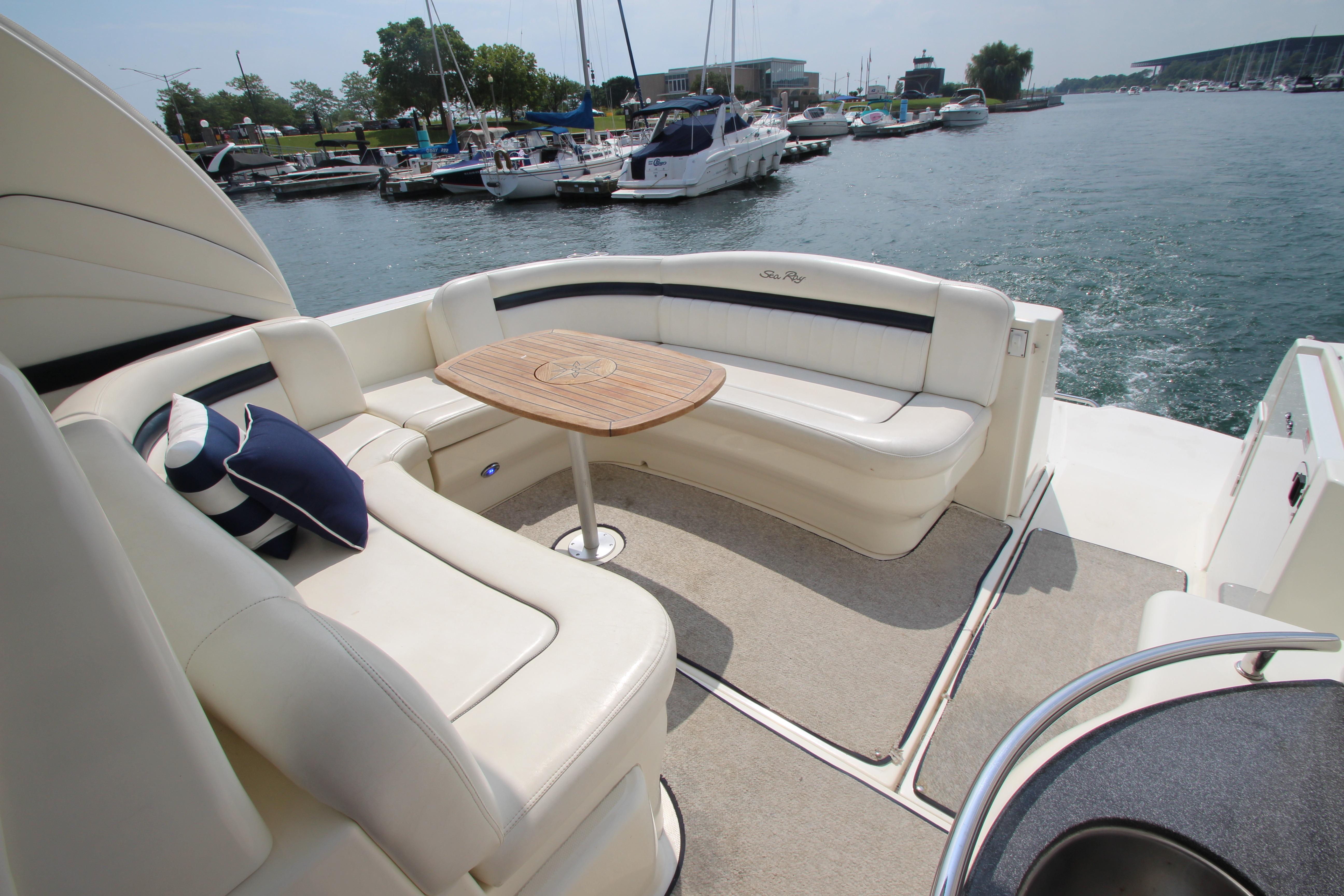 2004 Sea Ray 40 Sundancer yacht with elegant seating and table, docked at marina.