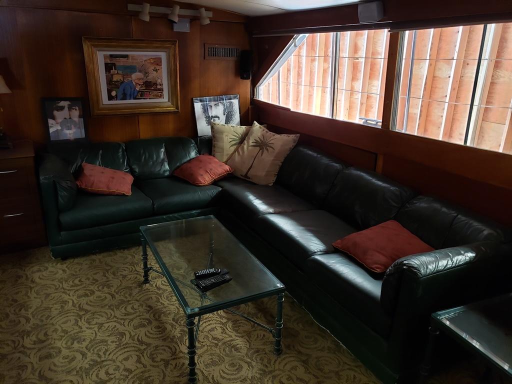 Luxurious 1964 Chris-Craft Constellation interior with leather sofas and glass coffee table.