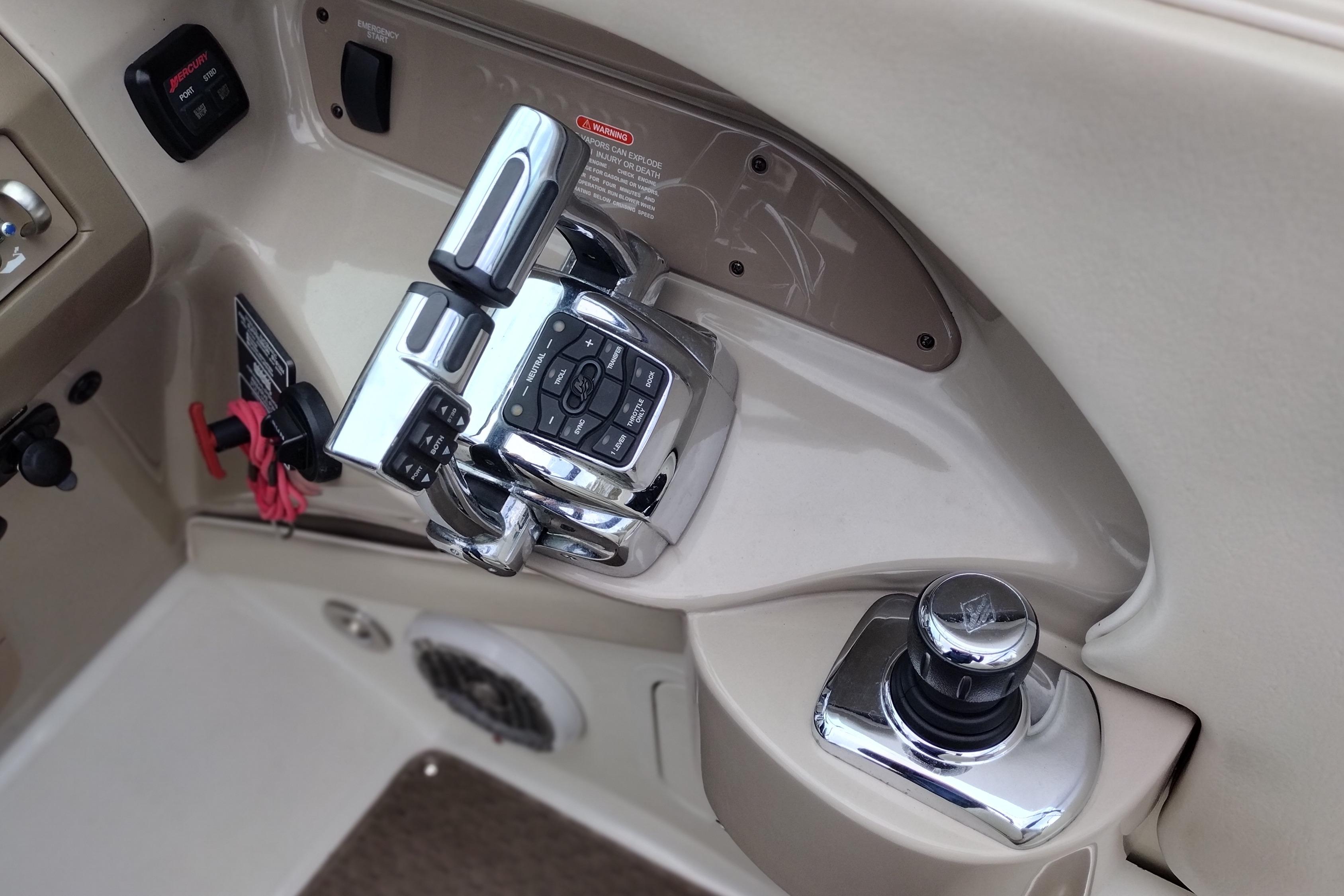 Control panel of a 2013 Sea Ray 300 SLX boat with chrome throttle and joystick.
