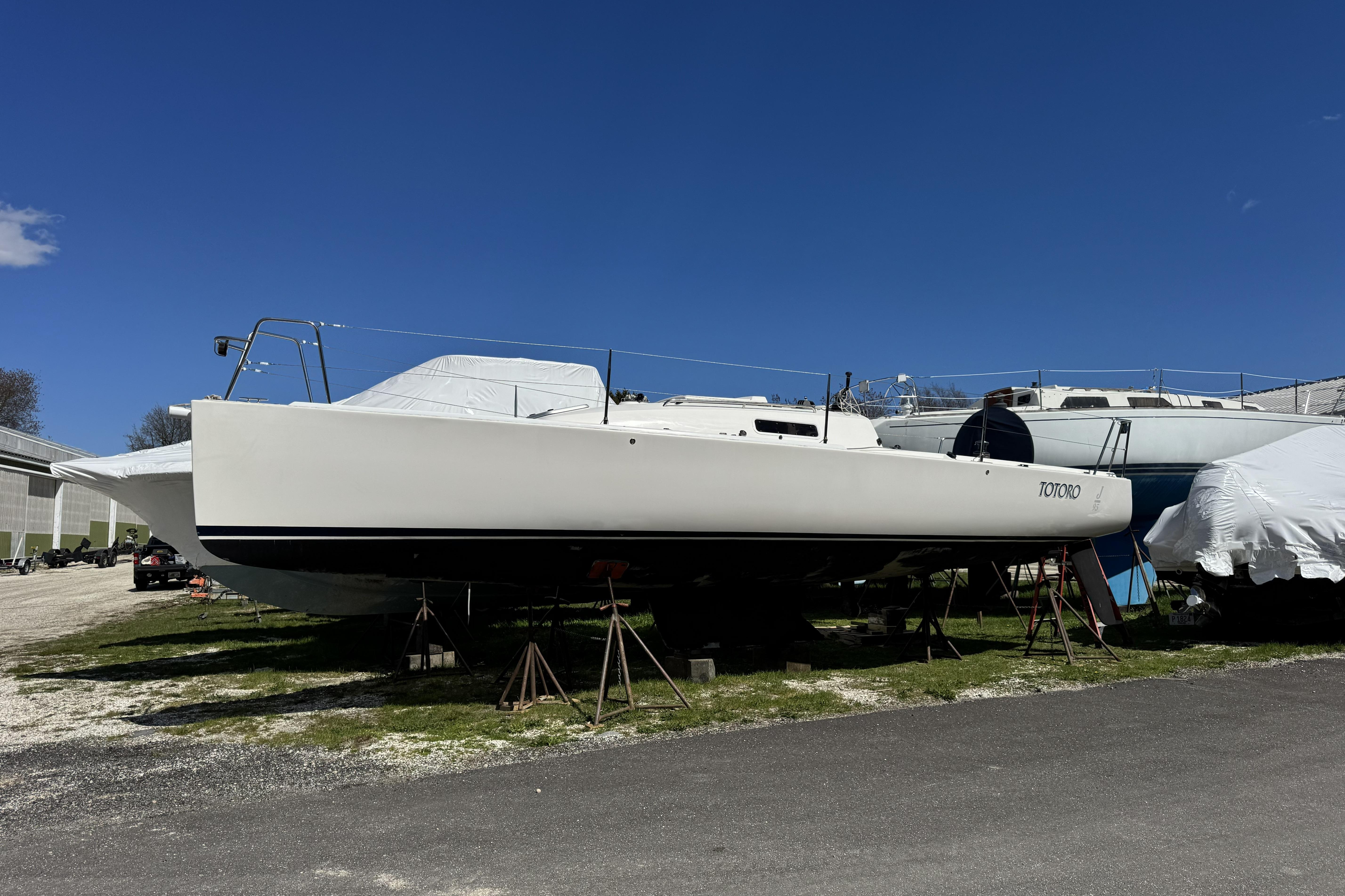 2011 J Boats J/95 sailboat on stands, clear blue sky background.