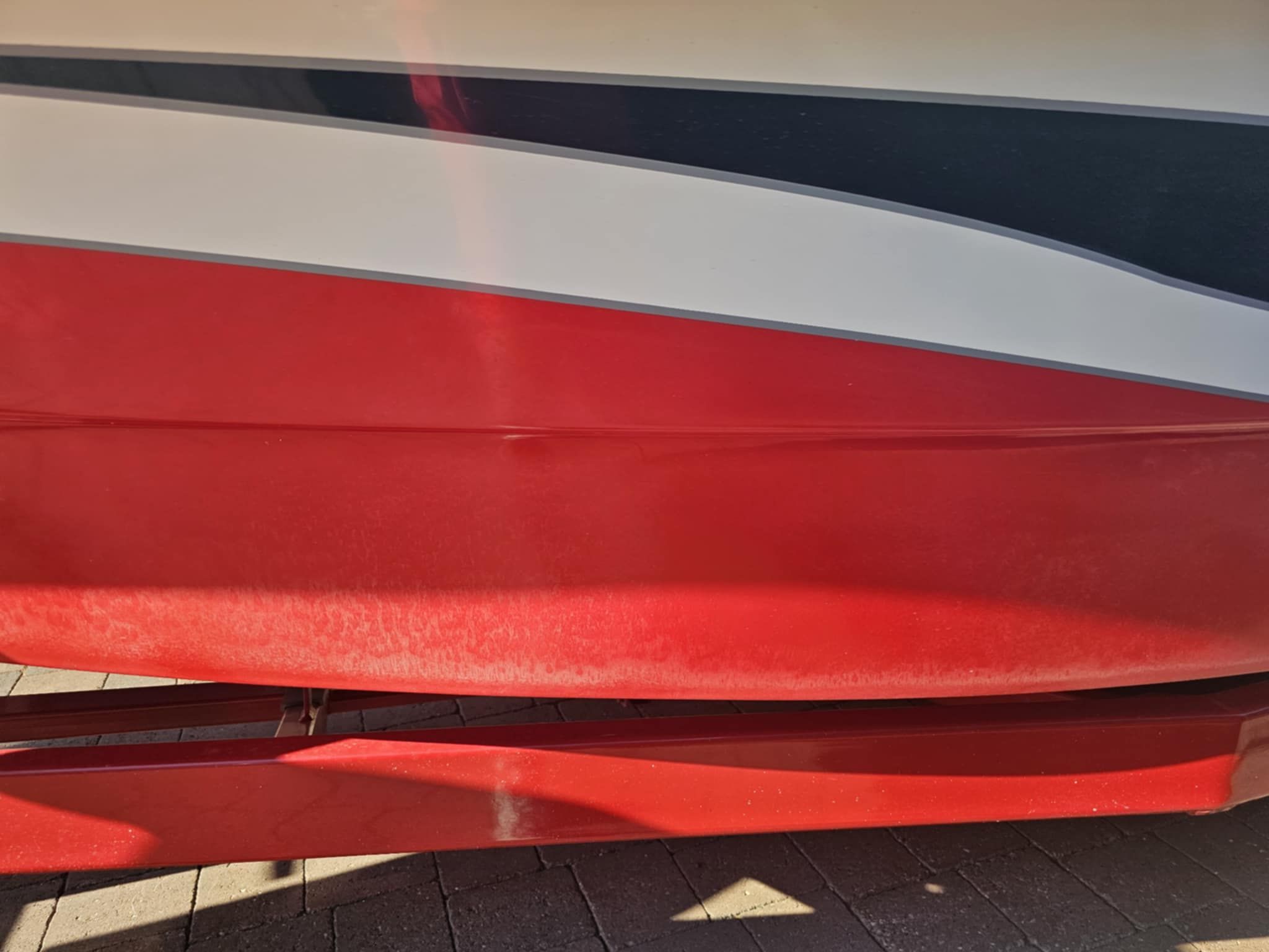 Red and white boat, MB PIGPR model 2006, on a trailer.