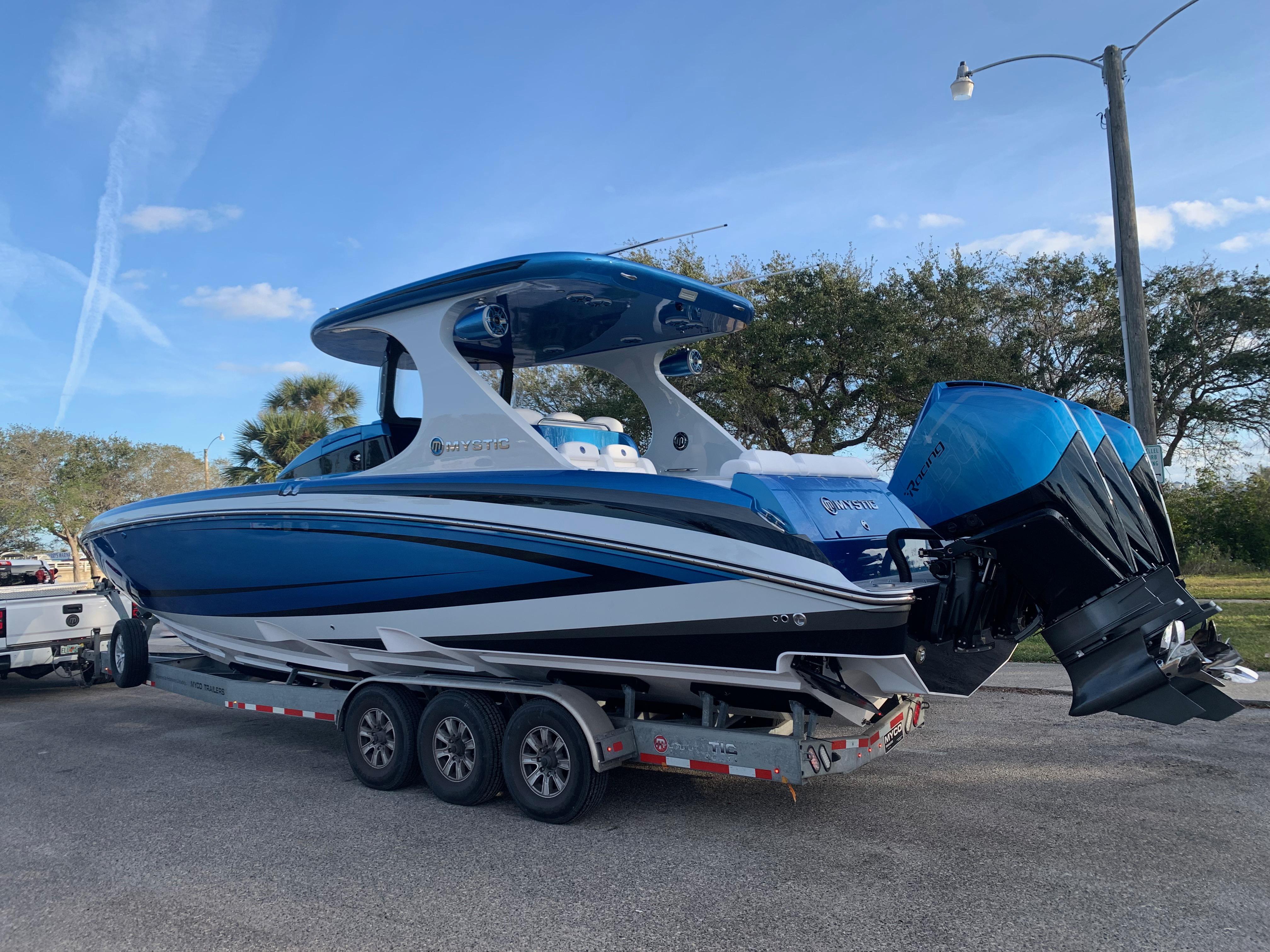 2023 Mystic Powerboats M3800 on trailer, blue and white design, parked outdoors.
