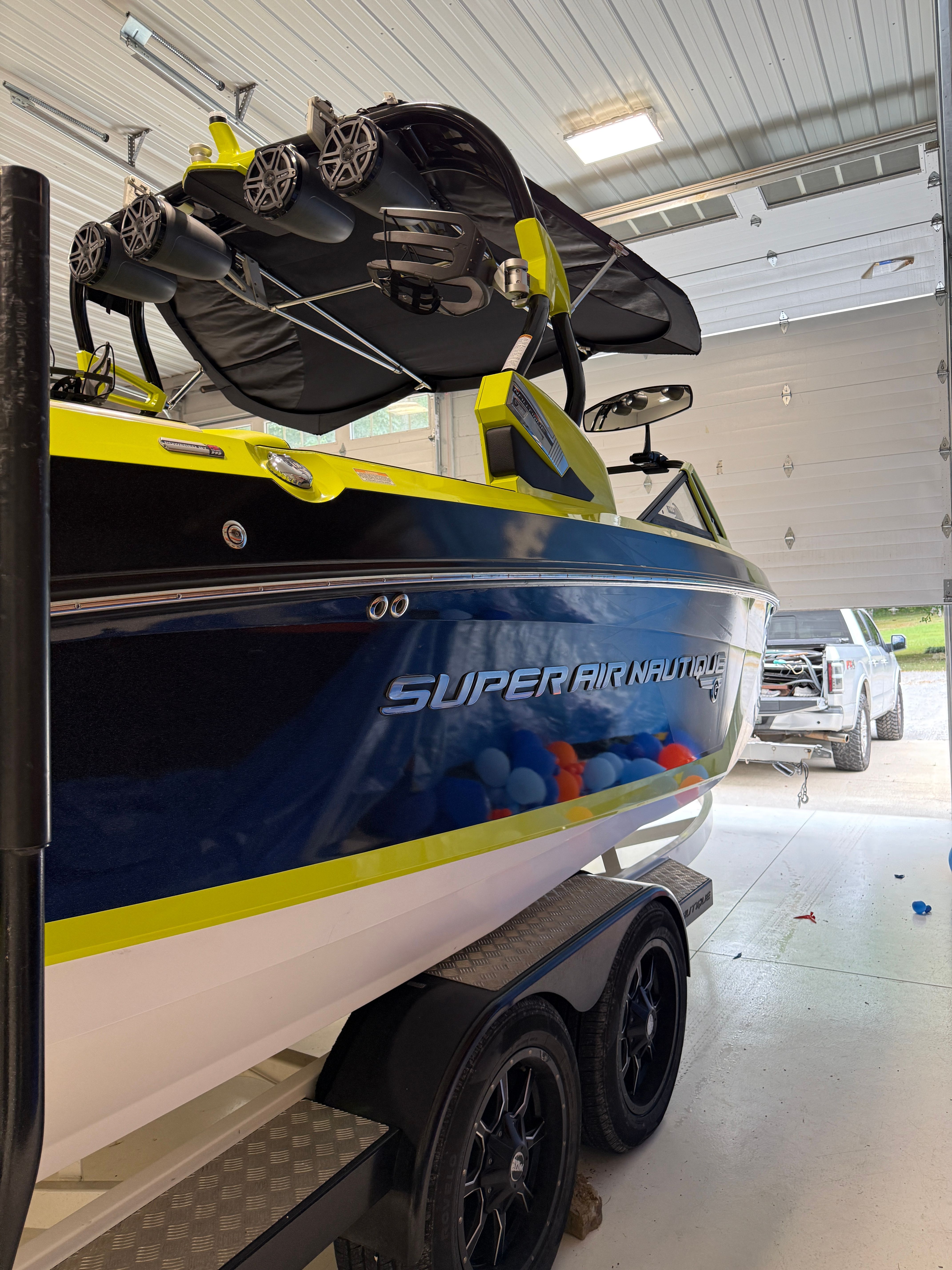 A 2016 Super Air Nautique G23 boat in a garage on a trailer.
