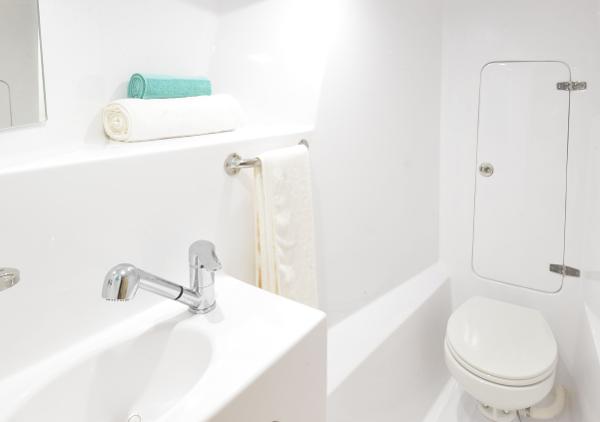 Modern bathroom in 2025 Seawind 1170 yacht with sink, toilet, and towels.