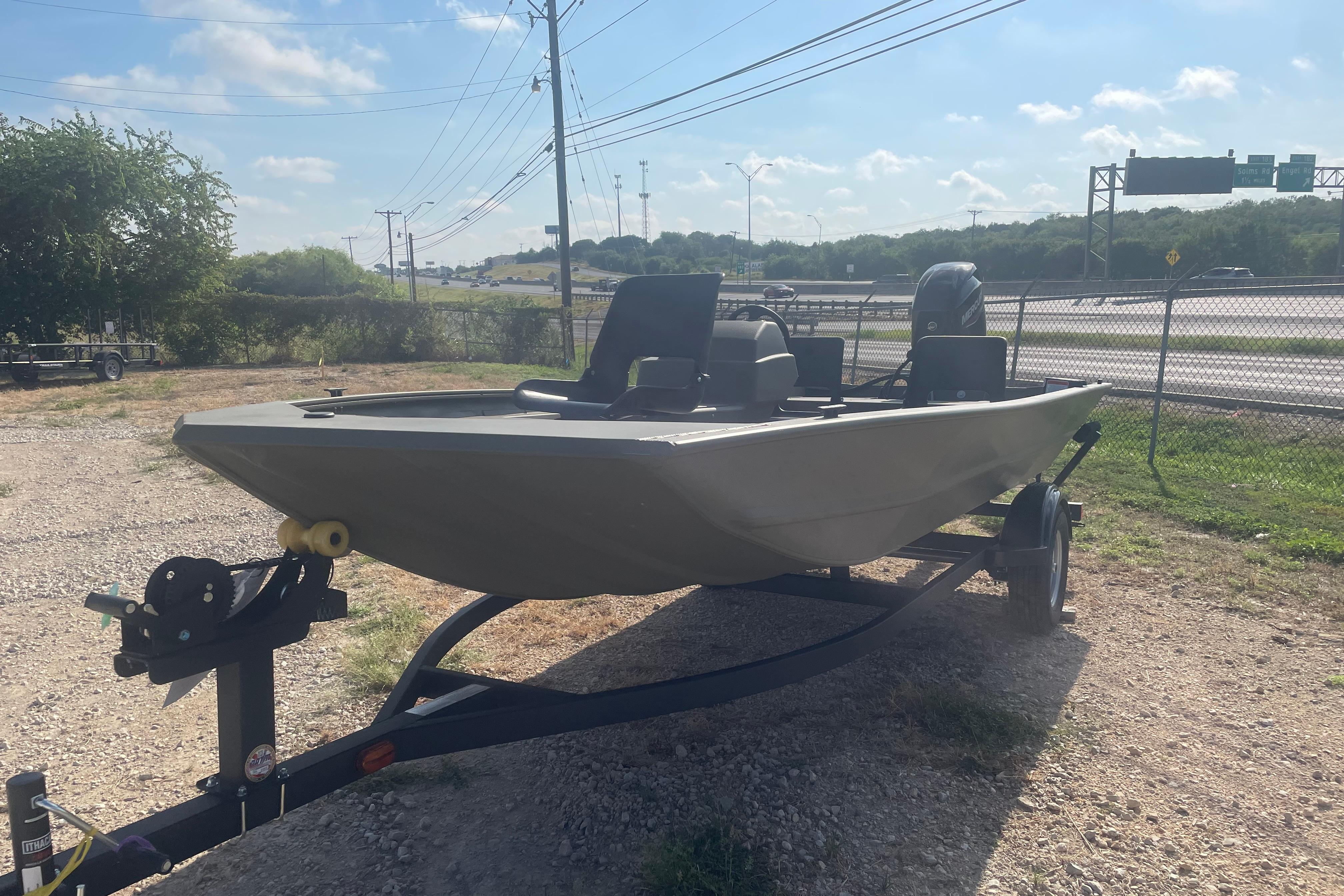 2026 Tracker Grizzly 1754 SC boat on trailer, parked outdoors under clear sky.