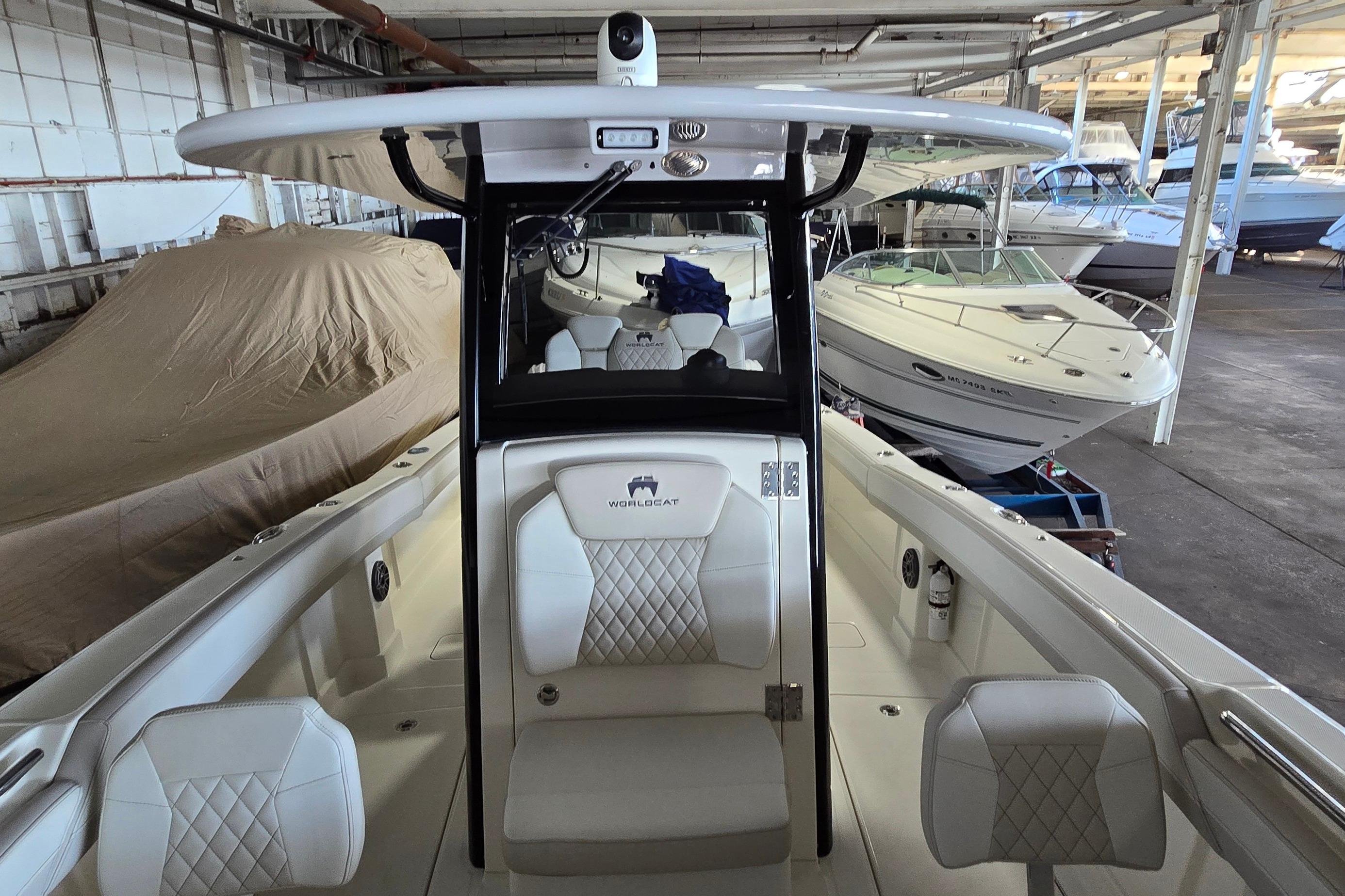 2024 WorldCat 280 CC-X boat interior in a storage facility, showcasing seating and helm.