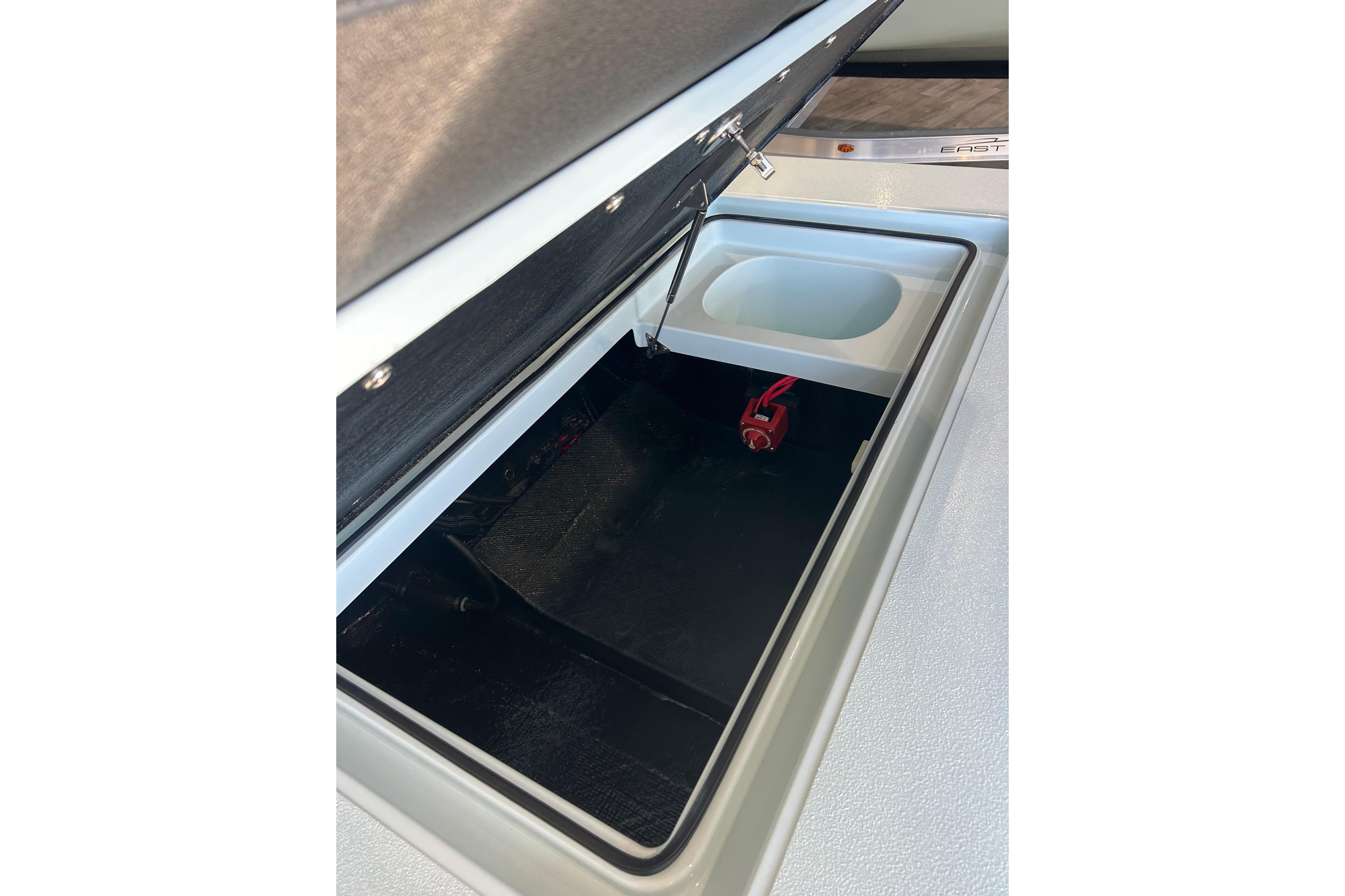 Open storage compartment in 2026 East Cape Evo 17X boat, featuring a secure latch and organized interior.