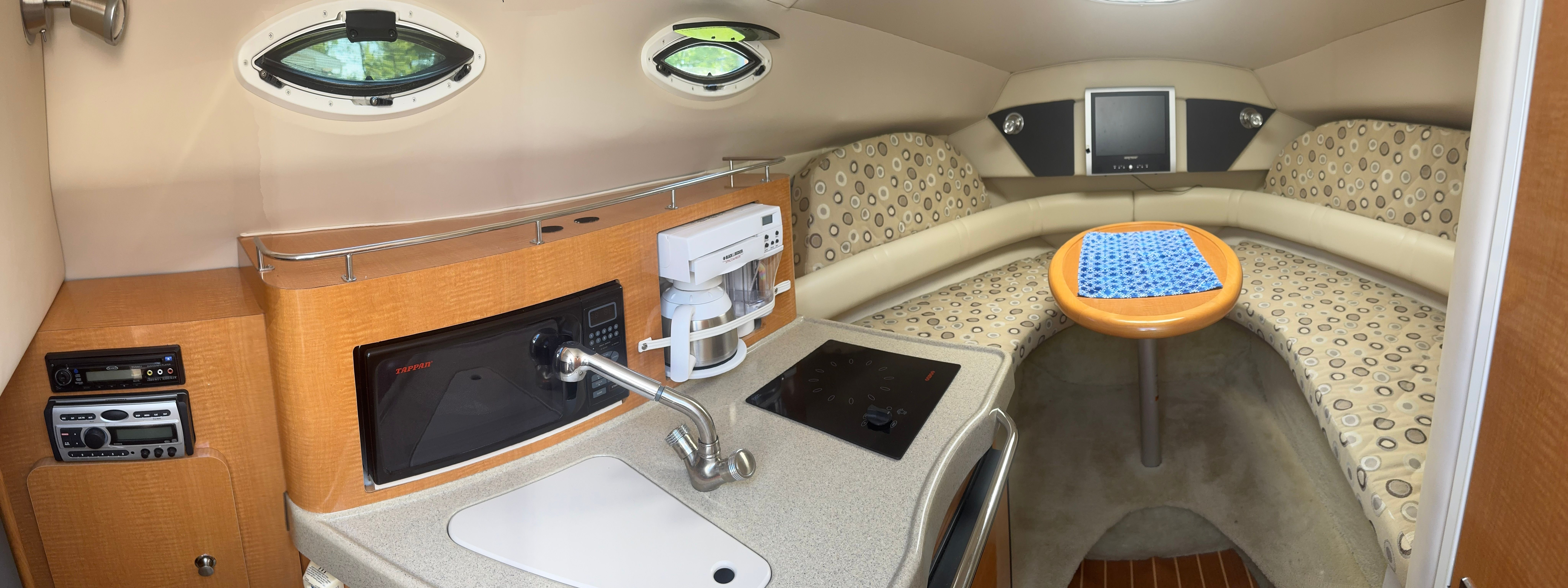 Interior of a modern yacht with a kitchenette and seating area.