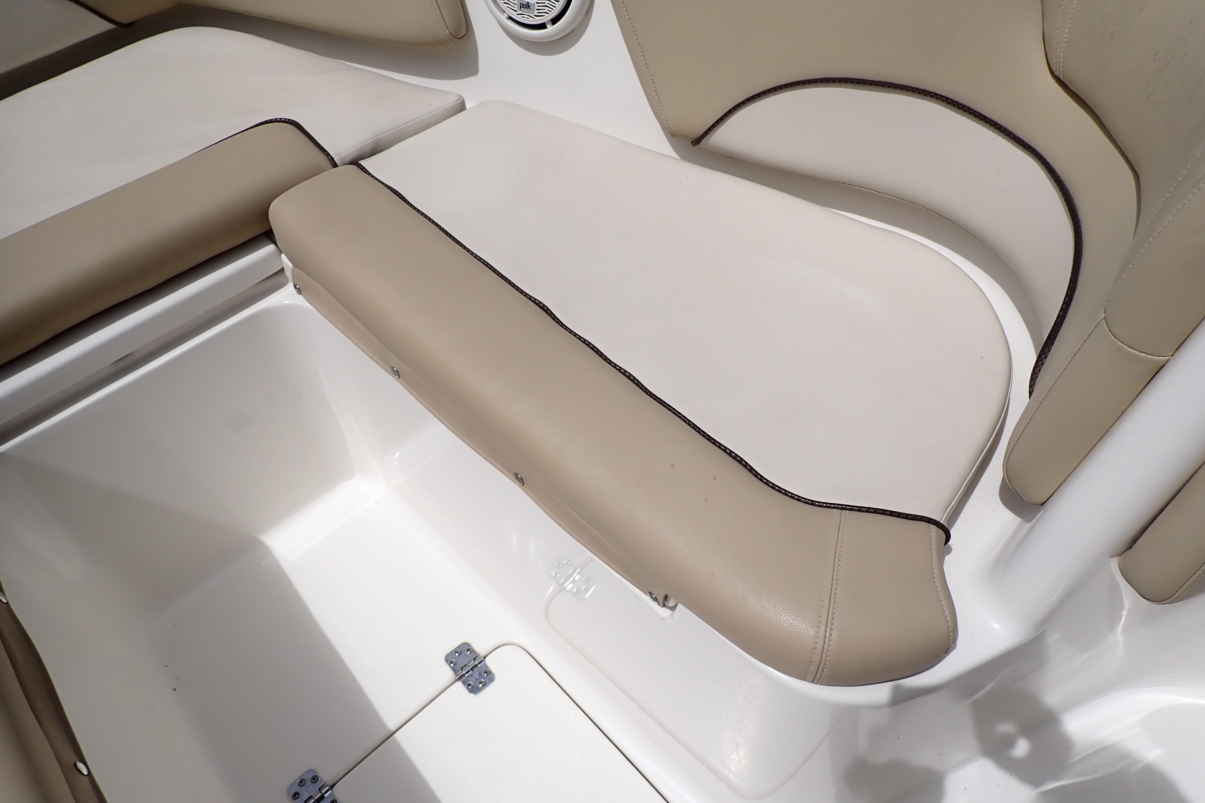 2019 Key West 263 FS boat interior seating with beige upholstery and storage compartment.