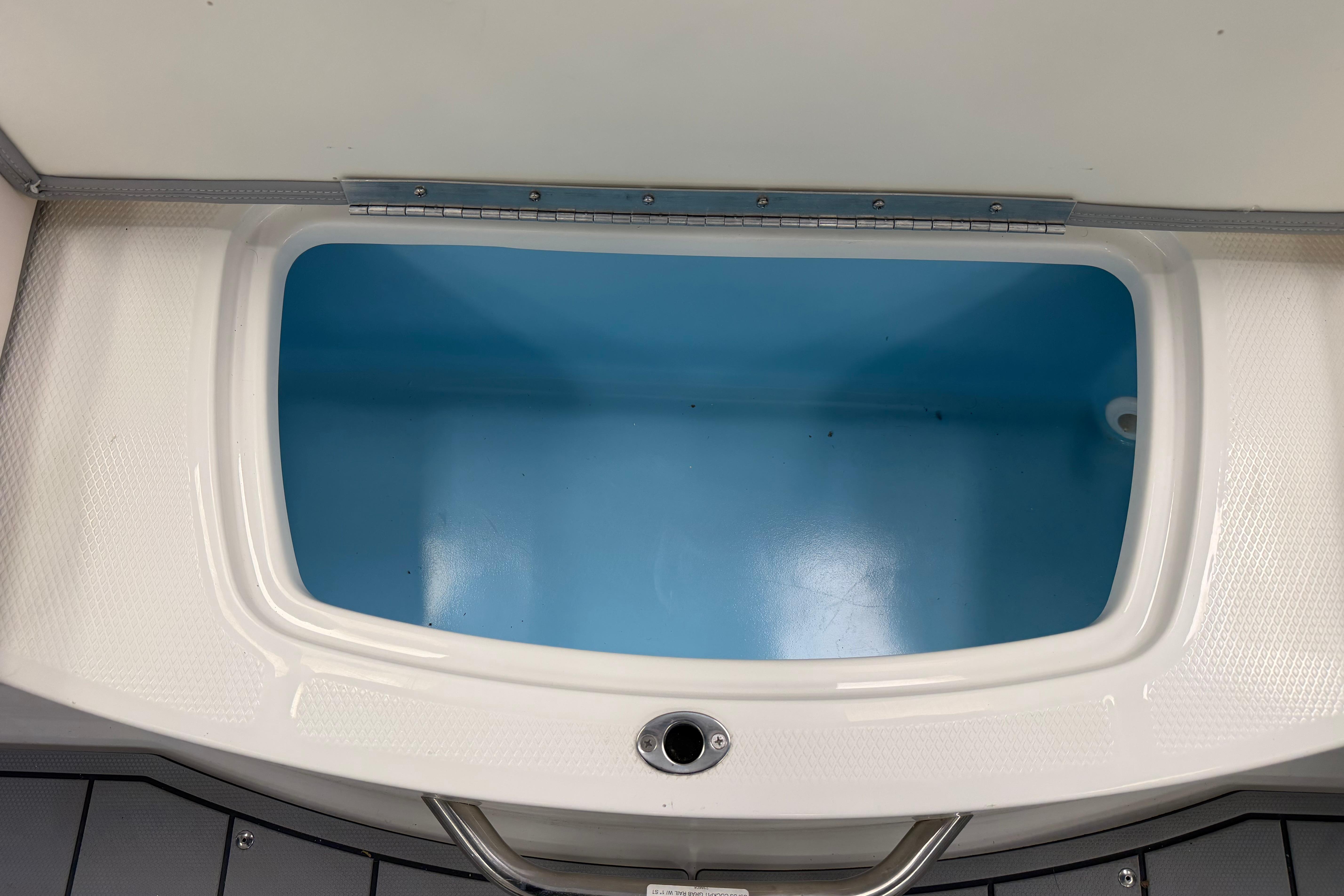 Livewell compartment in 2025 Chaparral 21 SSi OB boat, featuring a sleek white and blue design.