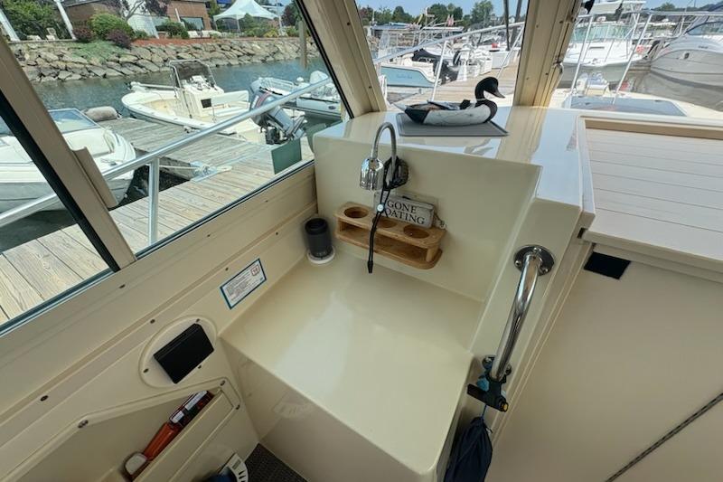 2003 Albin 28 Tournament Express boat interior with sink and marina view.