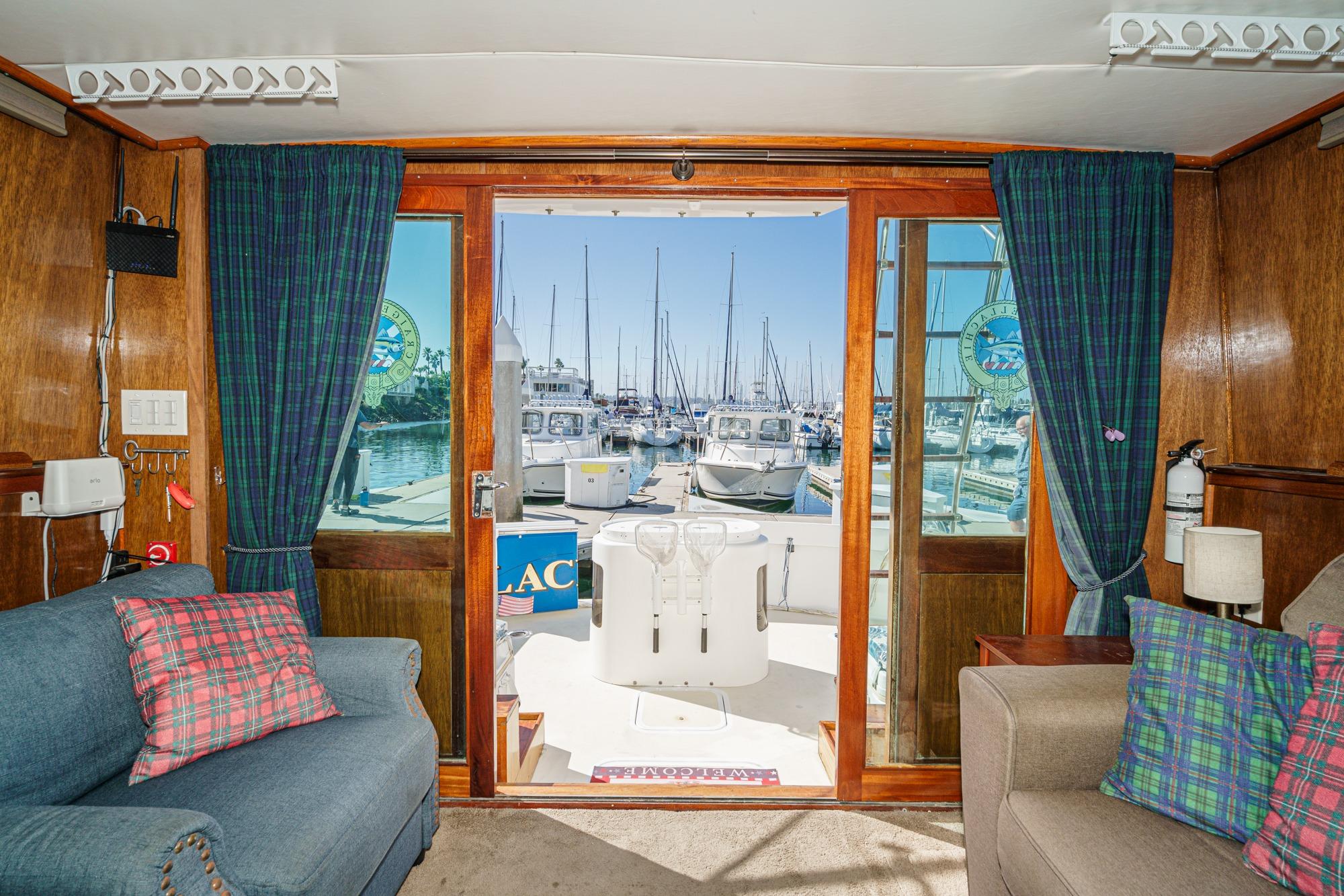 1974 Hatteras Convertible Sportfisher interior with marina view through glass doors.