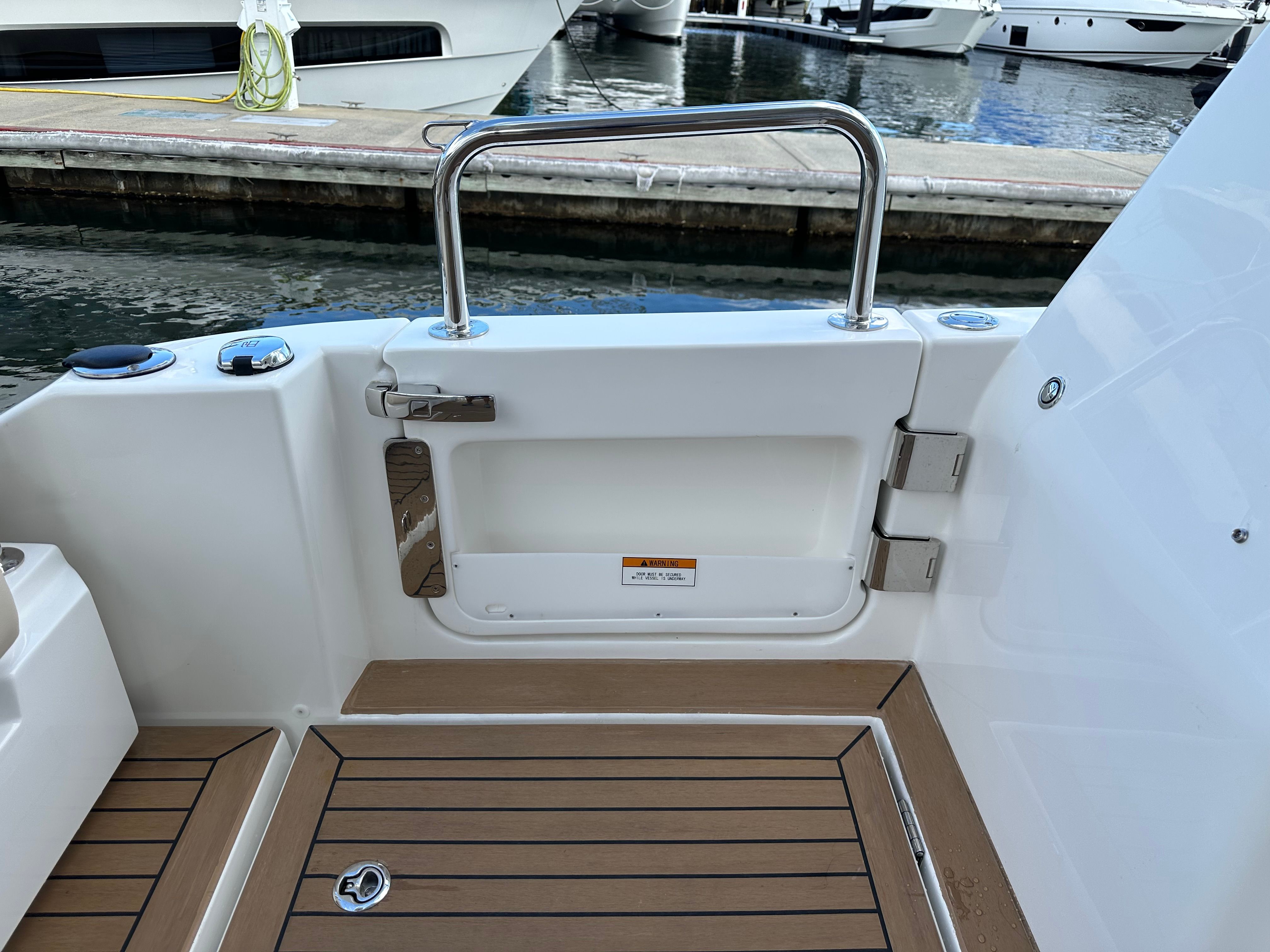 Aquila 36 Sport 2025 boat deck with teak flooring and stainless steel railing.