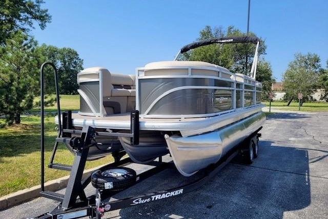 2025 Sun Tracker Party Barge 22 RF XP3 pontoon boat on trailer in parking lot.