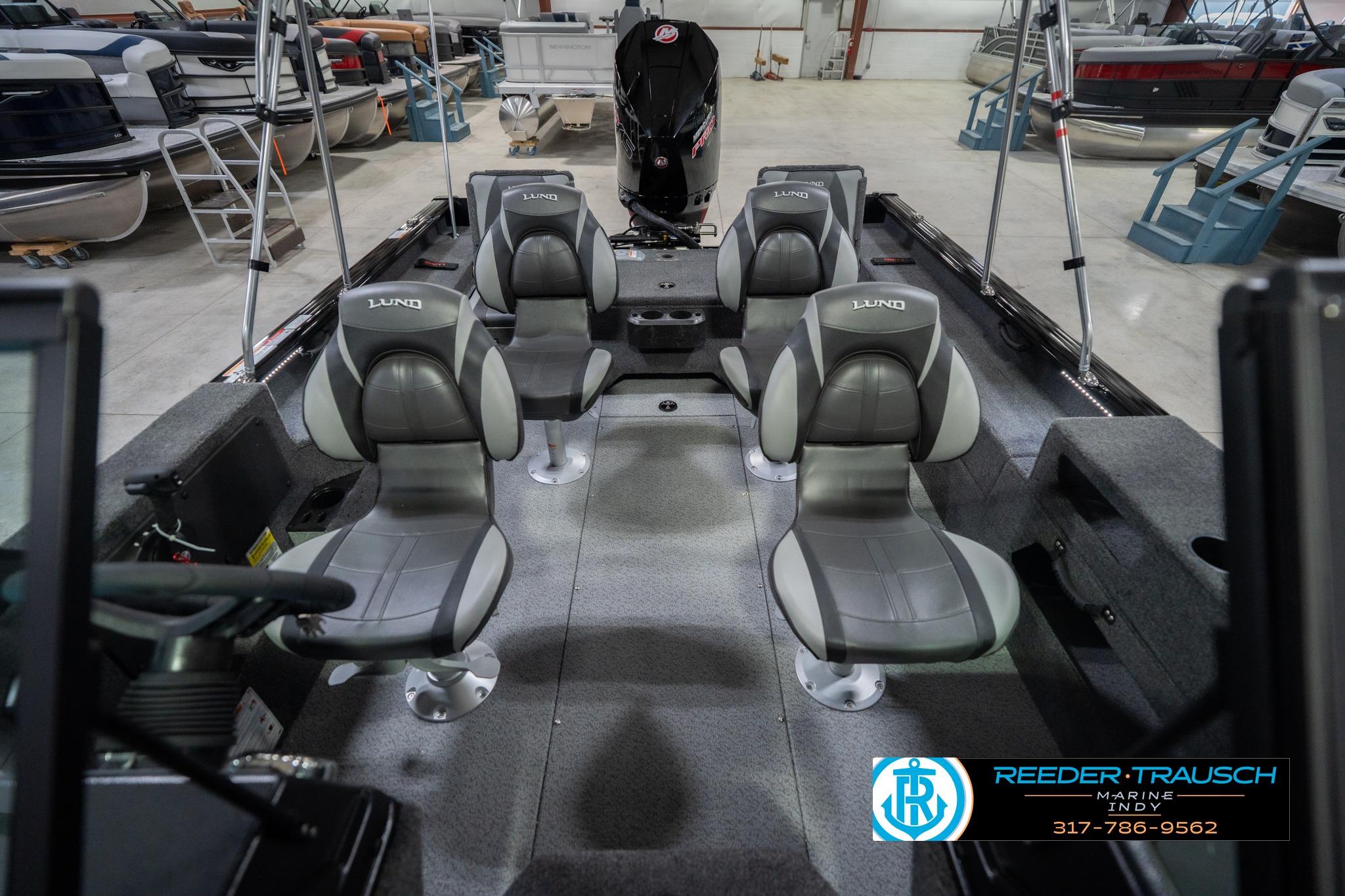 2026 Lund 2075 Impact XS boat interior with four gray seats in a showroom.