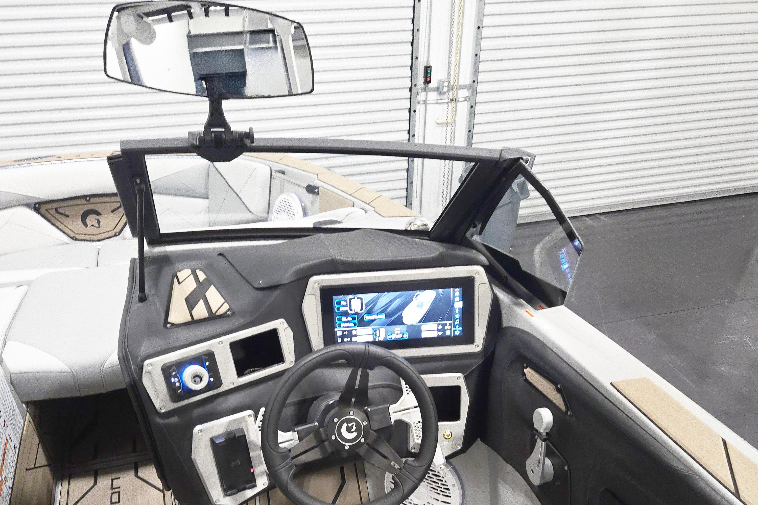 2026 Centurion Nv243 boat dashboard with touchscreen display and steering wheel.