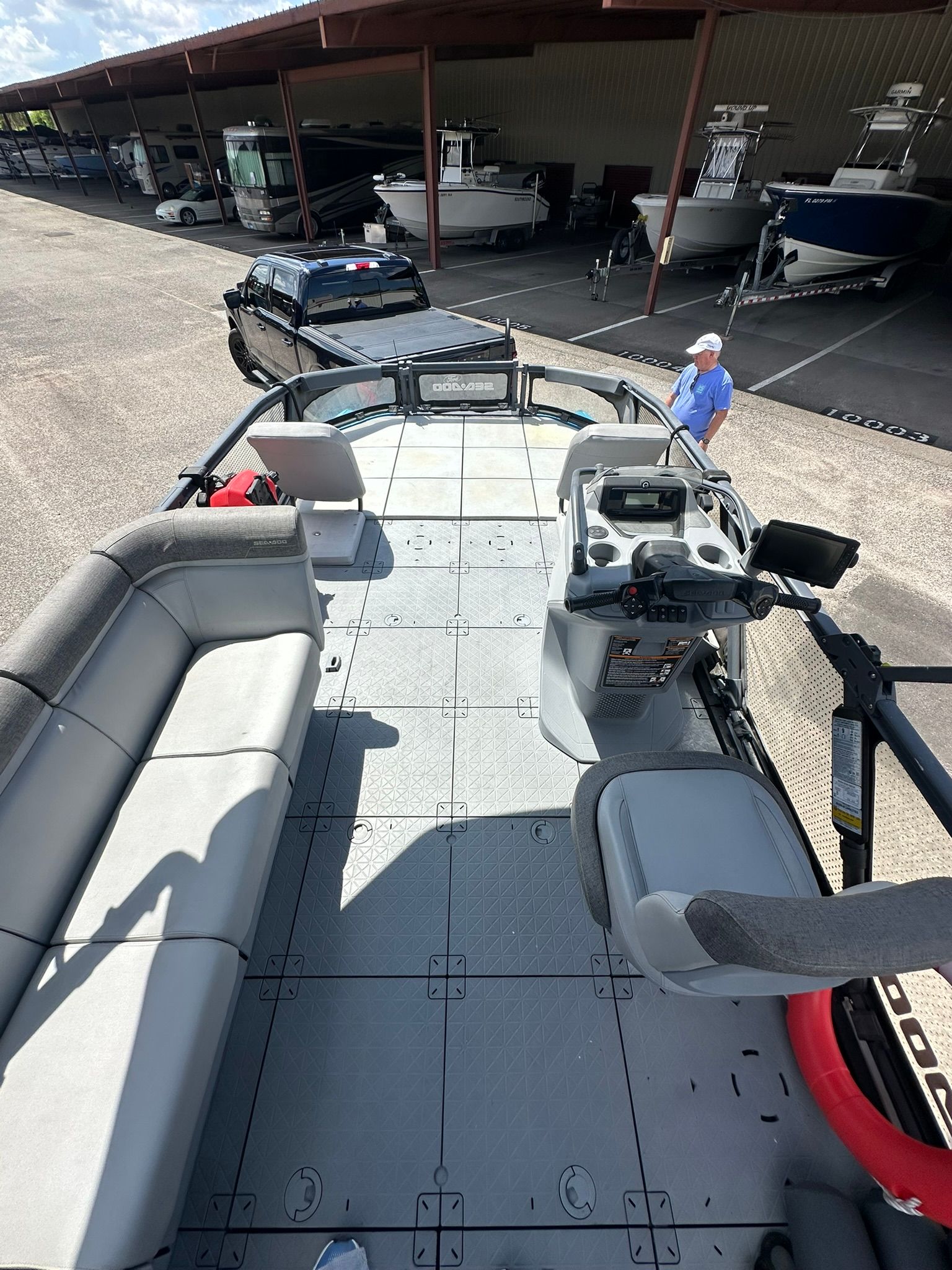 The image shows the deck of a 2023 Sea-Doo 21 SWITCH SPORT boat docked in a marina.