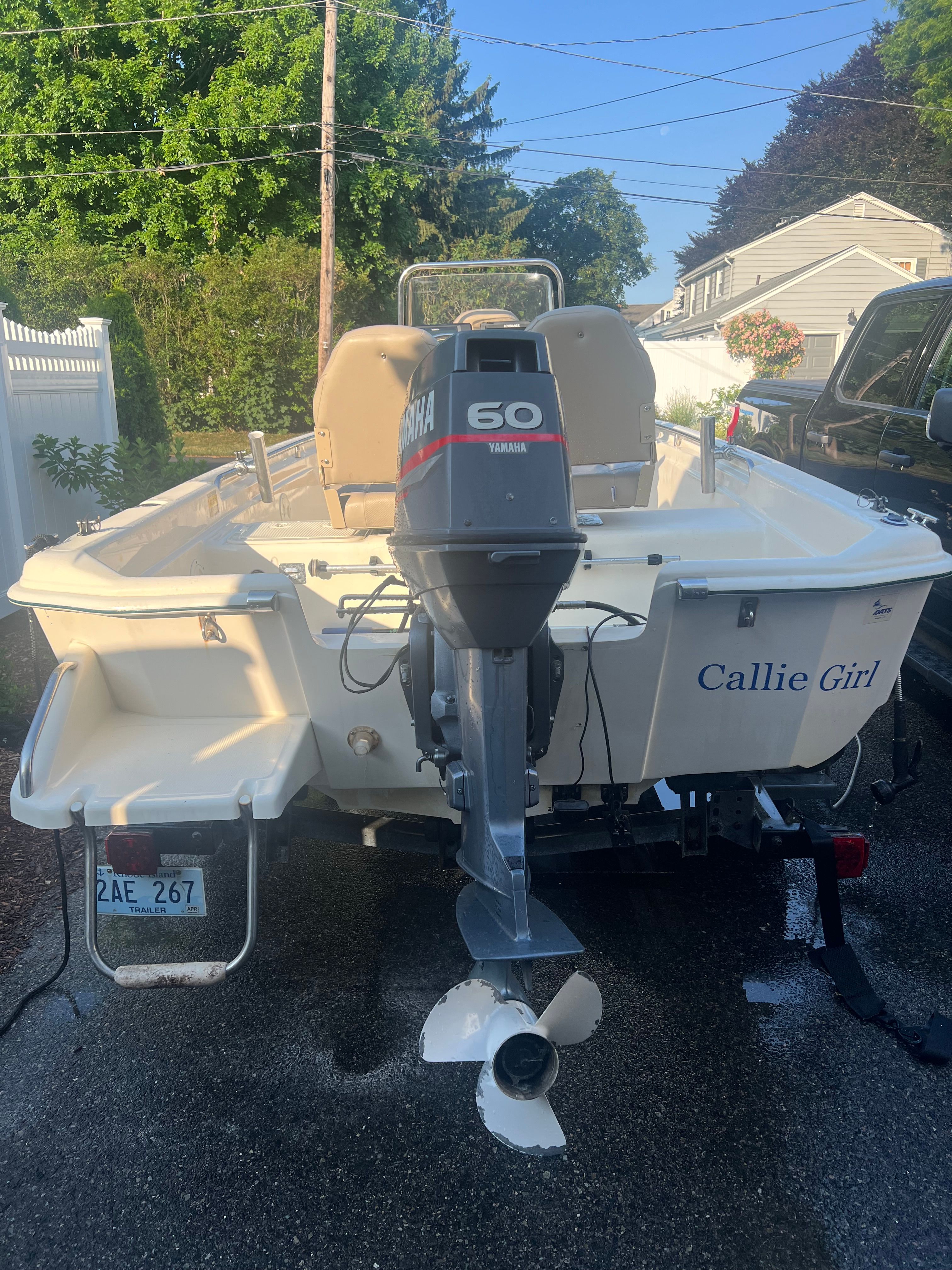 A 2001 Scout 151 Sportfish boat with a Yamaha 60 outboard motor, parked in a driveway.