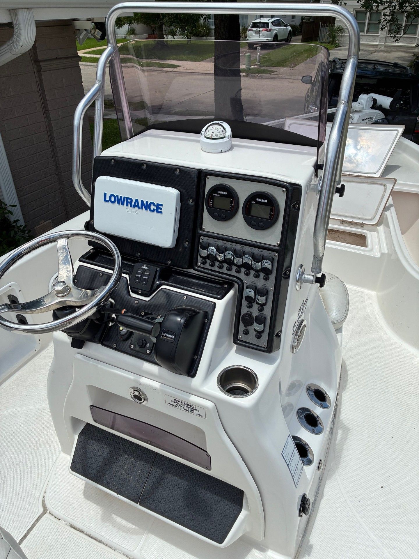 The image shows a boat's helm with a Lowrance screen and various instruments.