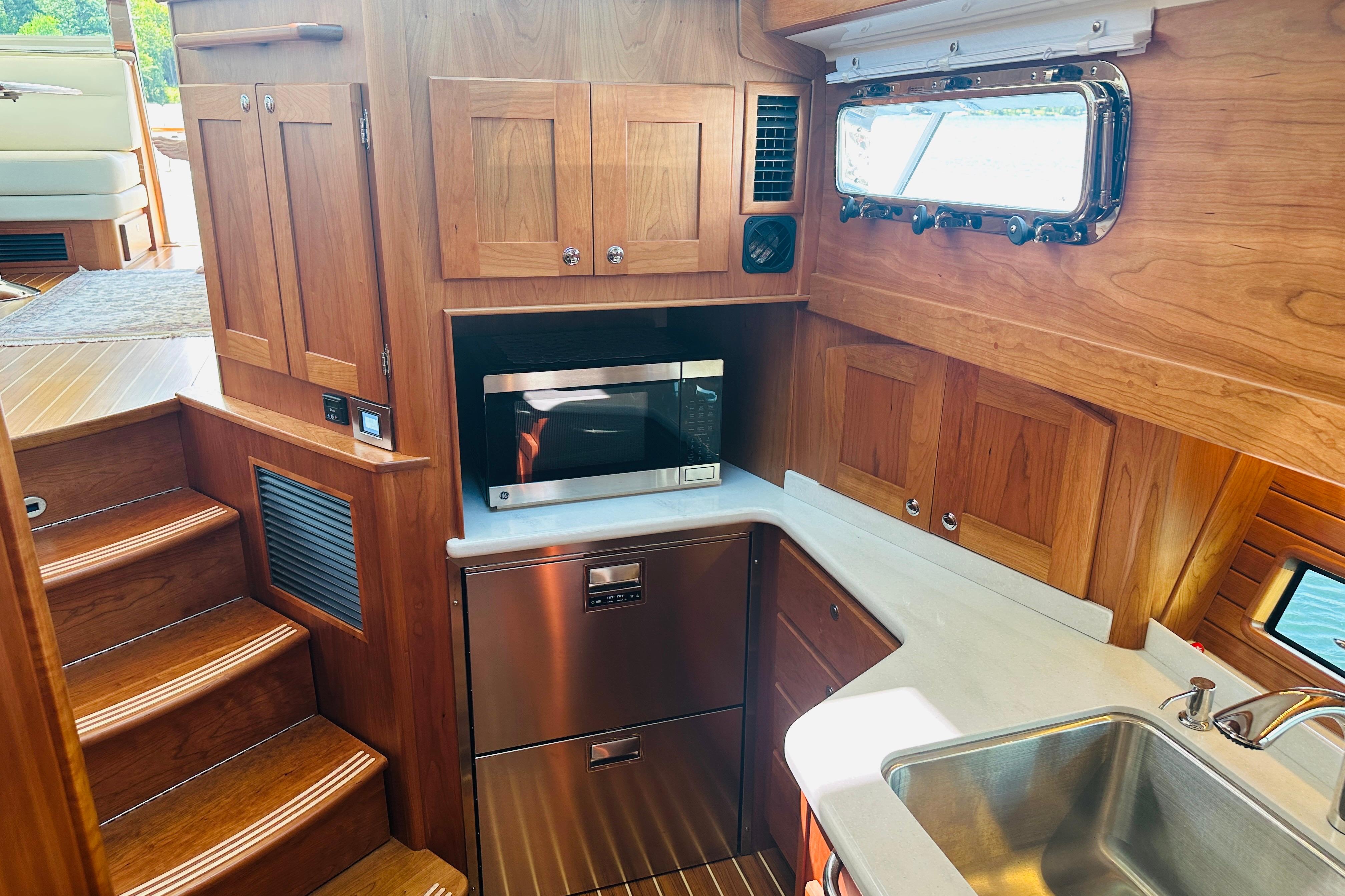 Interior of 2025 Sabre 48 Salon Express yacht kitchen with wood cabinetry and stainless steel appliances.