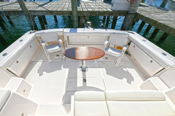 2008 Tiara Yachts 4200 Open cockpit with seating and table, docked by the water.