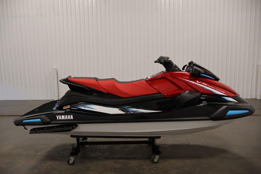 2026 Yamaha WaveRunner VX Deluxe in red and black, displayed indoors on a stand.