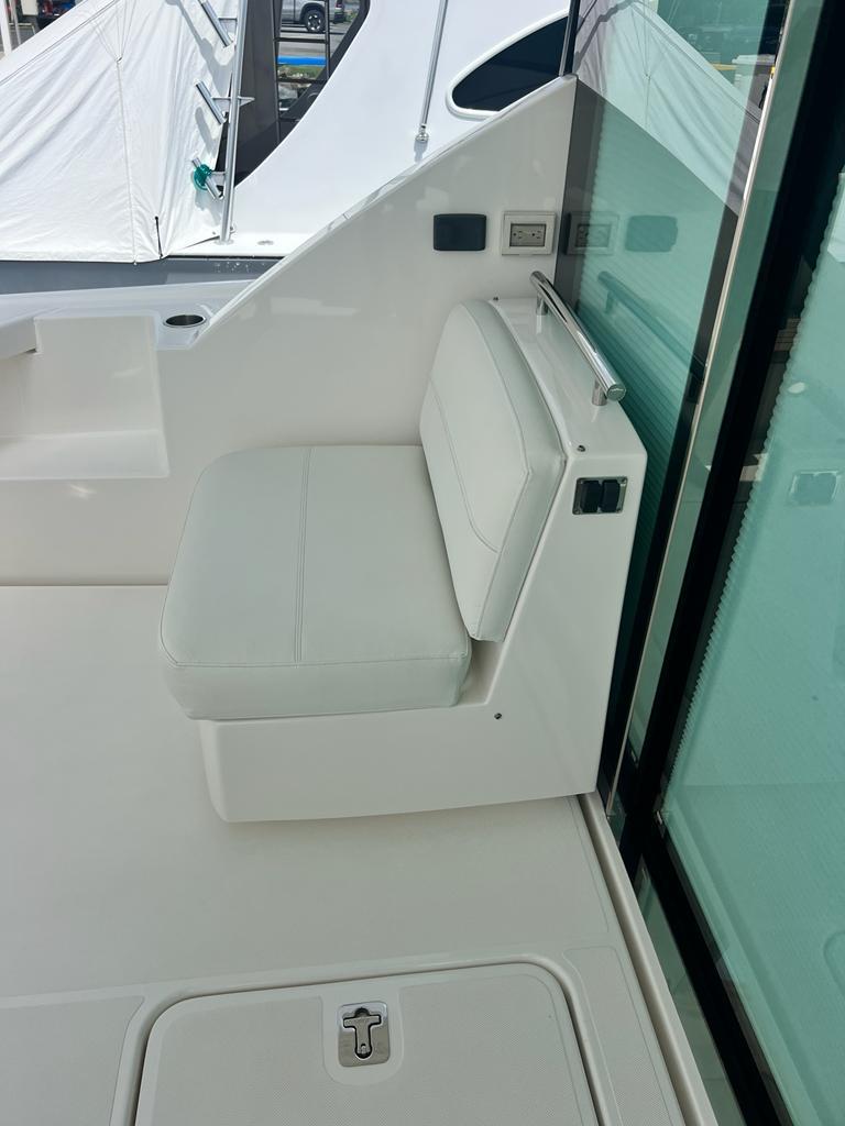 2023 Tiara Yachts C49 Coupe, sleek white seating area on deck.