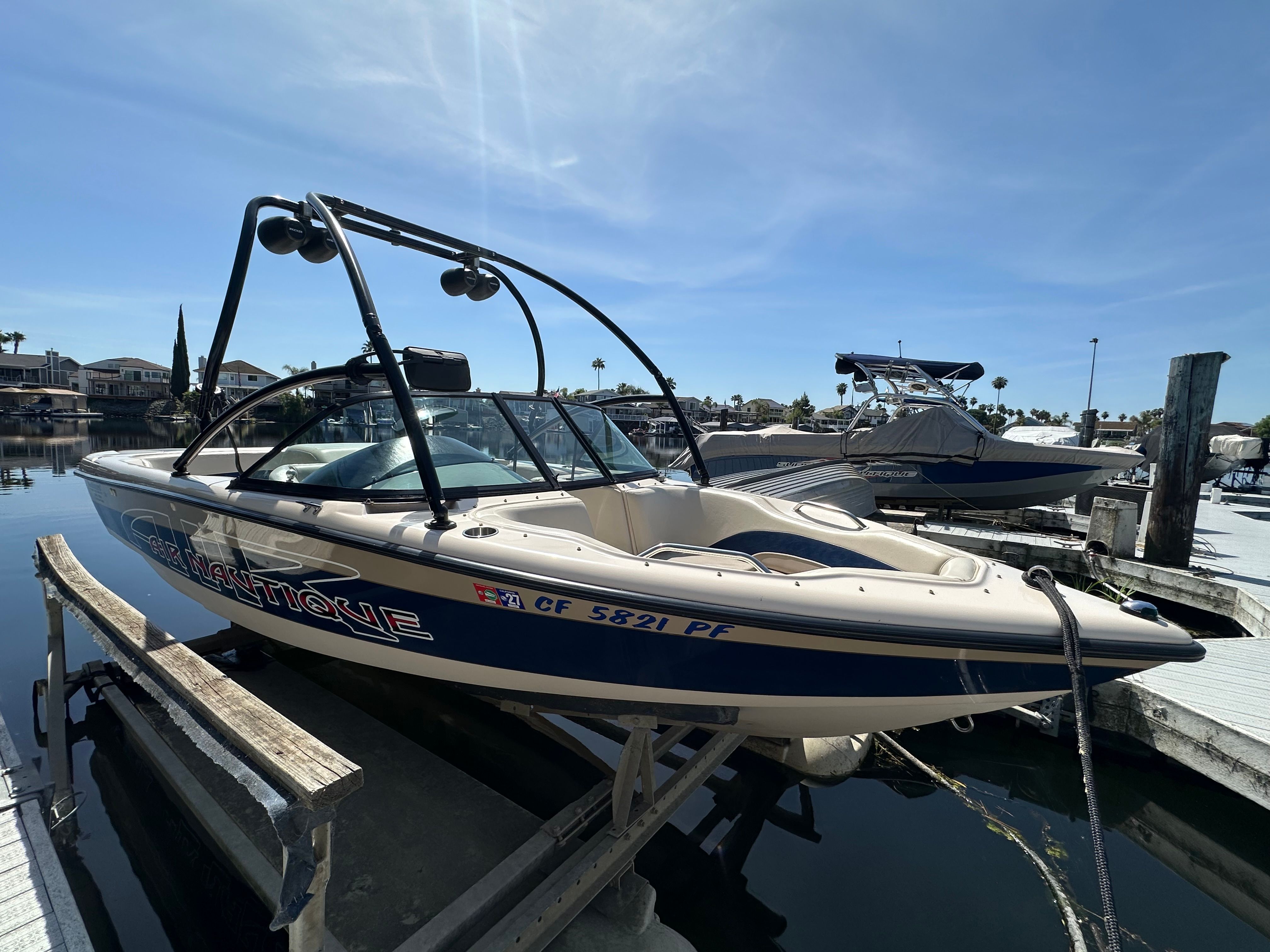 1998 Correct Craft Air Nautique boat at dock.