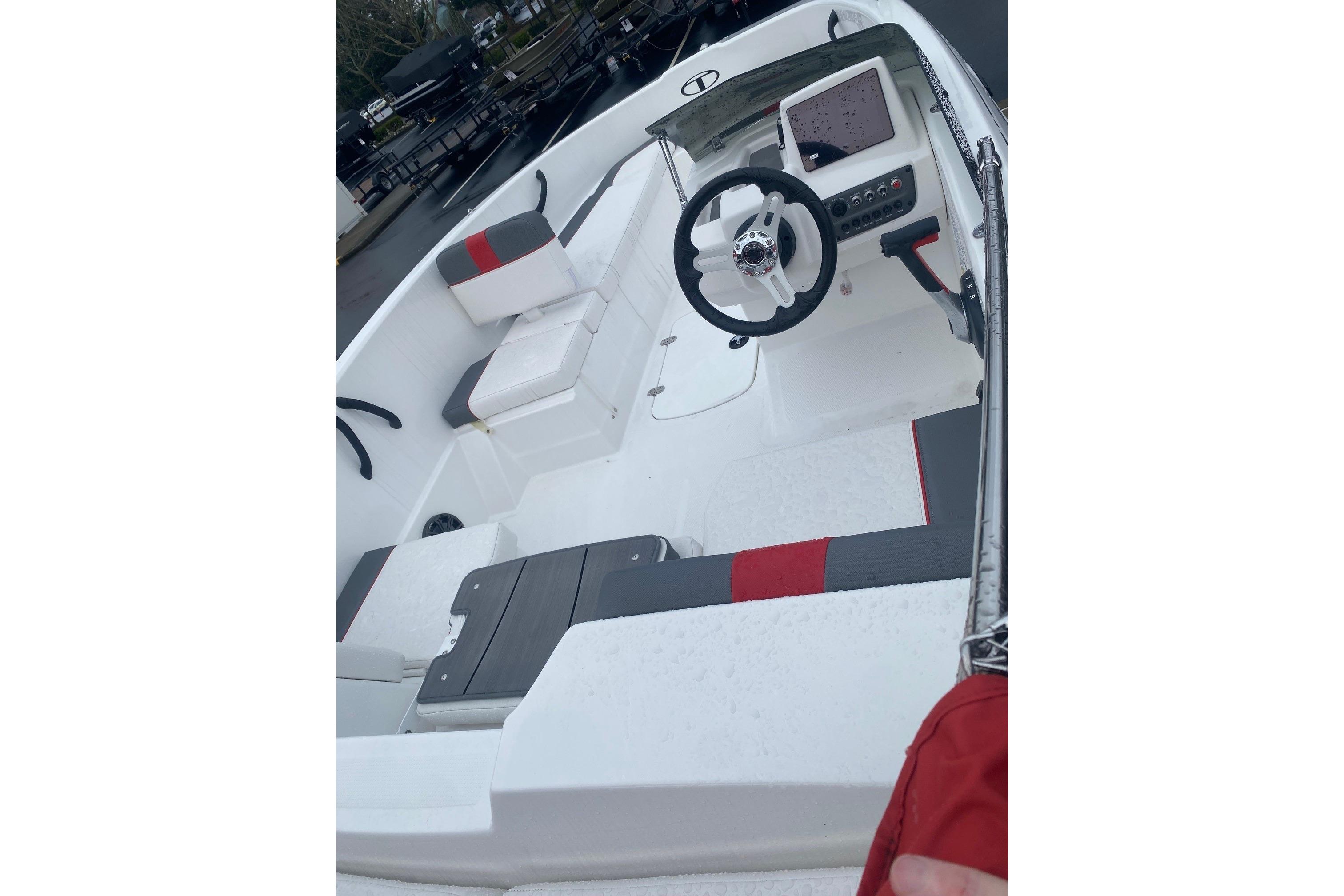 2026 Tahoe T16 boat interior with steering wheel and seating, featuring red and gray accents.