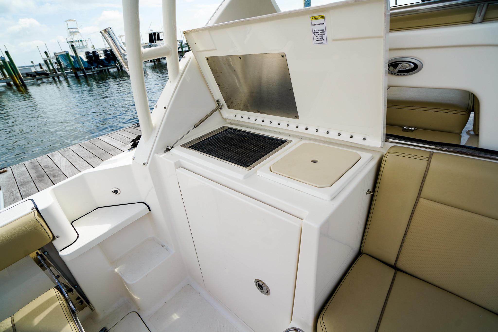 2020 Pursuit OS 325 Offshore boat interior with seating and utility area by the dock.