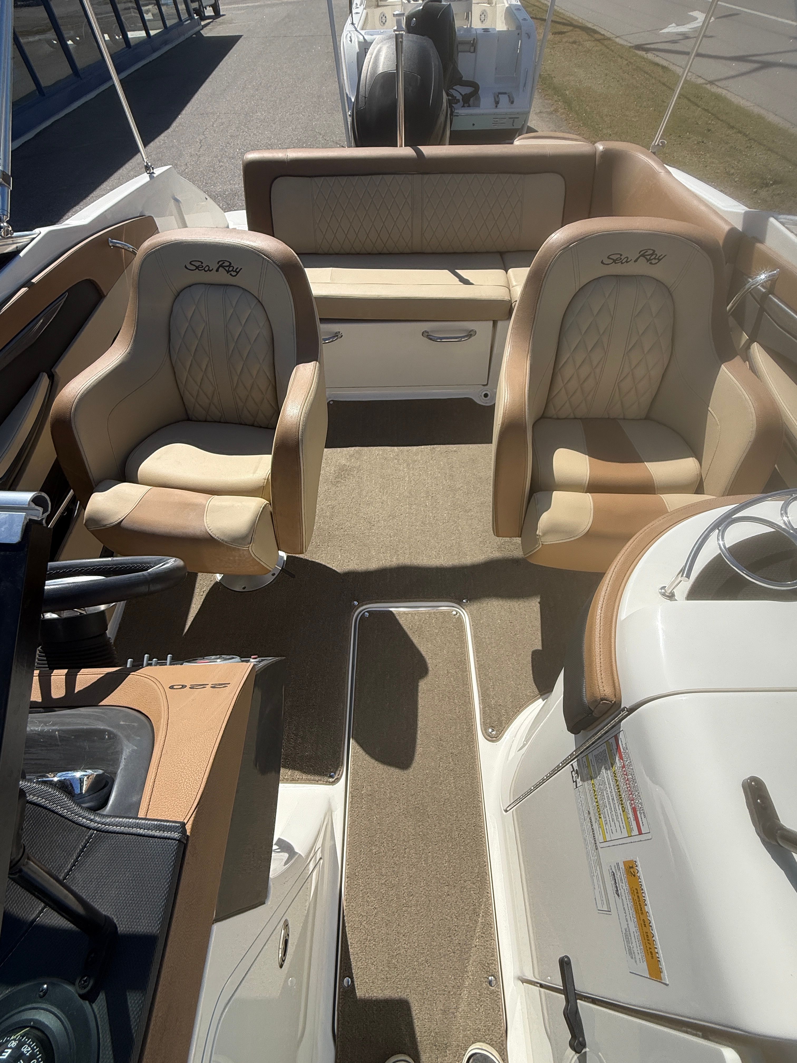Interior of a 2015 Sea Ray 220 Sundeck OB with beige seating.