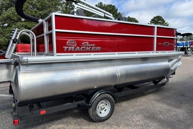 2026 Sun Tracker Party Barge 16 DLX pontoon boat with red exterior on trailer.