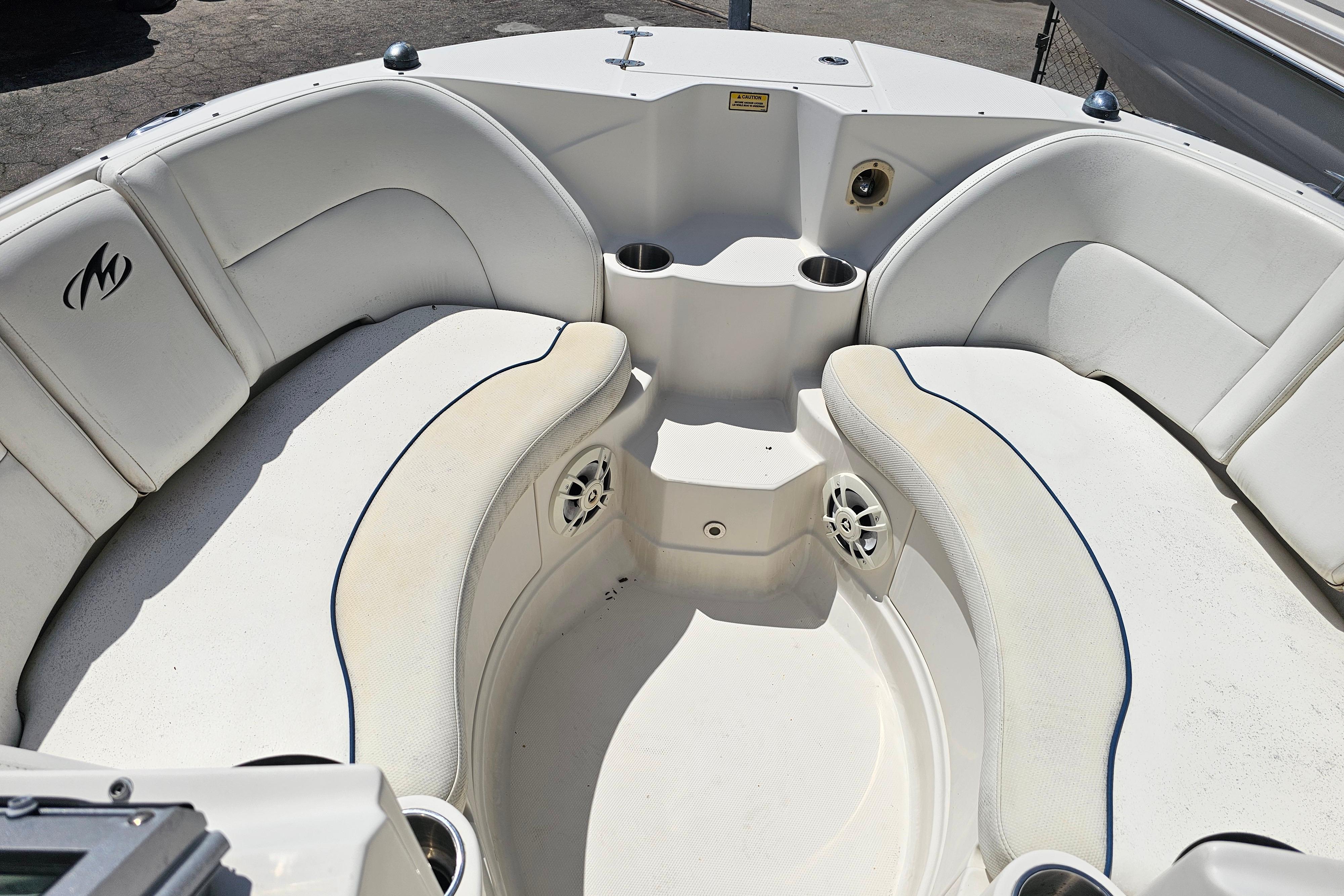 Interior seating of a 2008 Monterey 220 Explorer boat with cup holders and speakers.