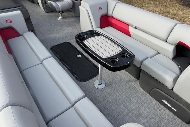 2026 Sun Tracker Party Barge 24 XP3 interior with gray and red seating, central table.
