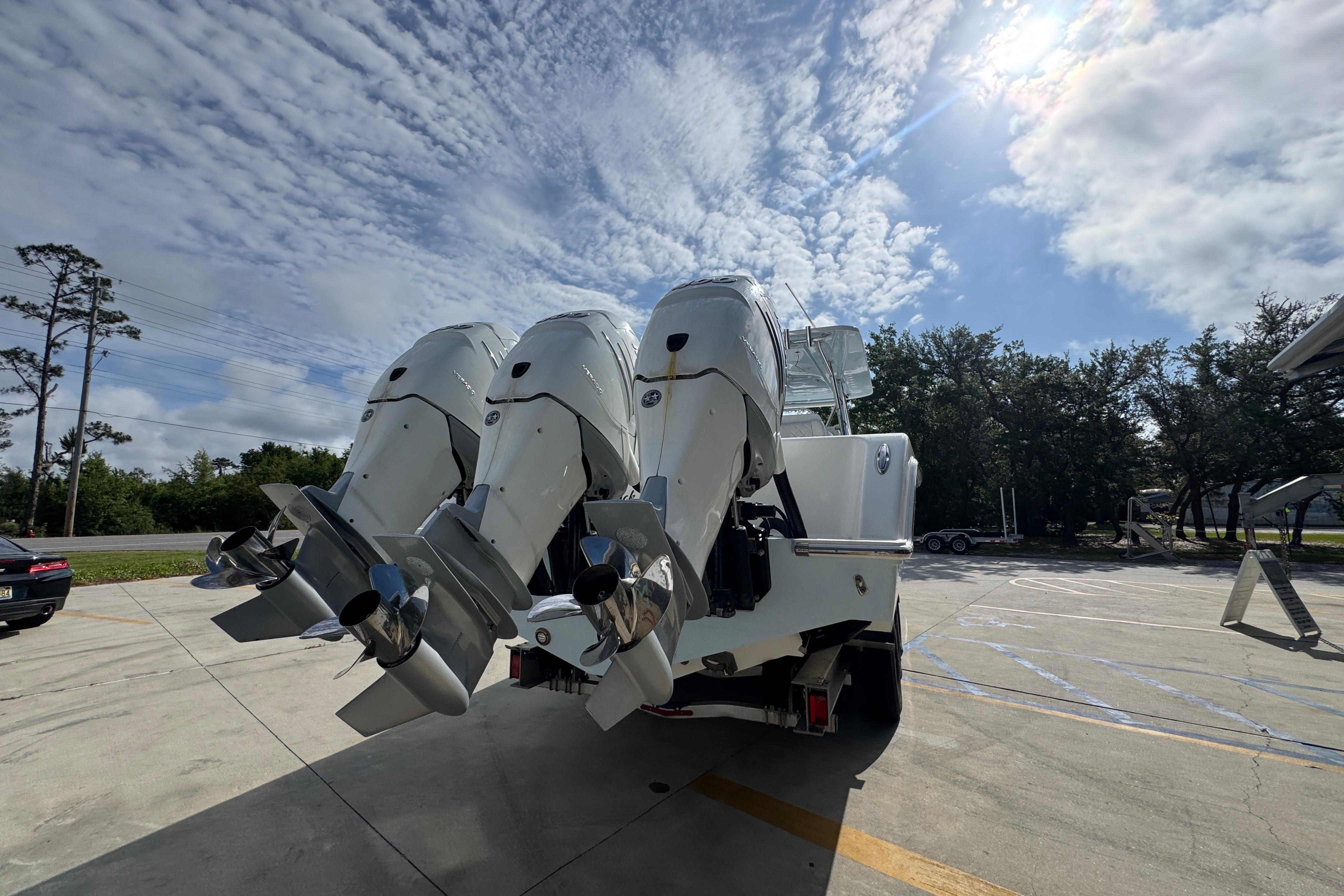 2017 Invincible 39 Open Fisherman with triple outboard engines under a partly cloudy sky.