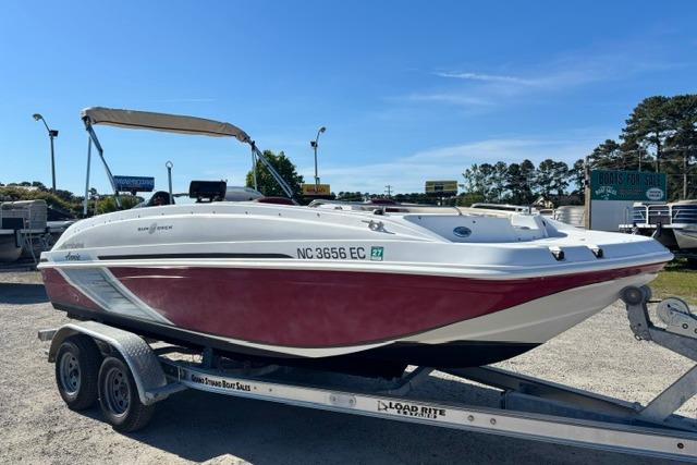 2016 Hurricane SunDeck Sport 188 OB boat on trailer, red and white design, sunny day.