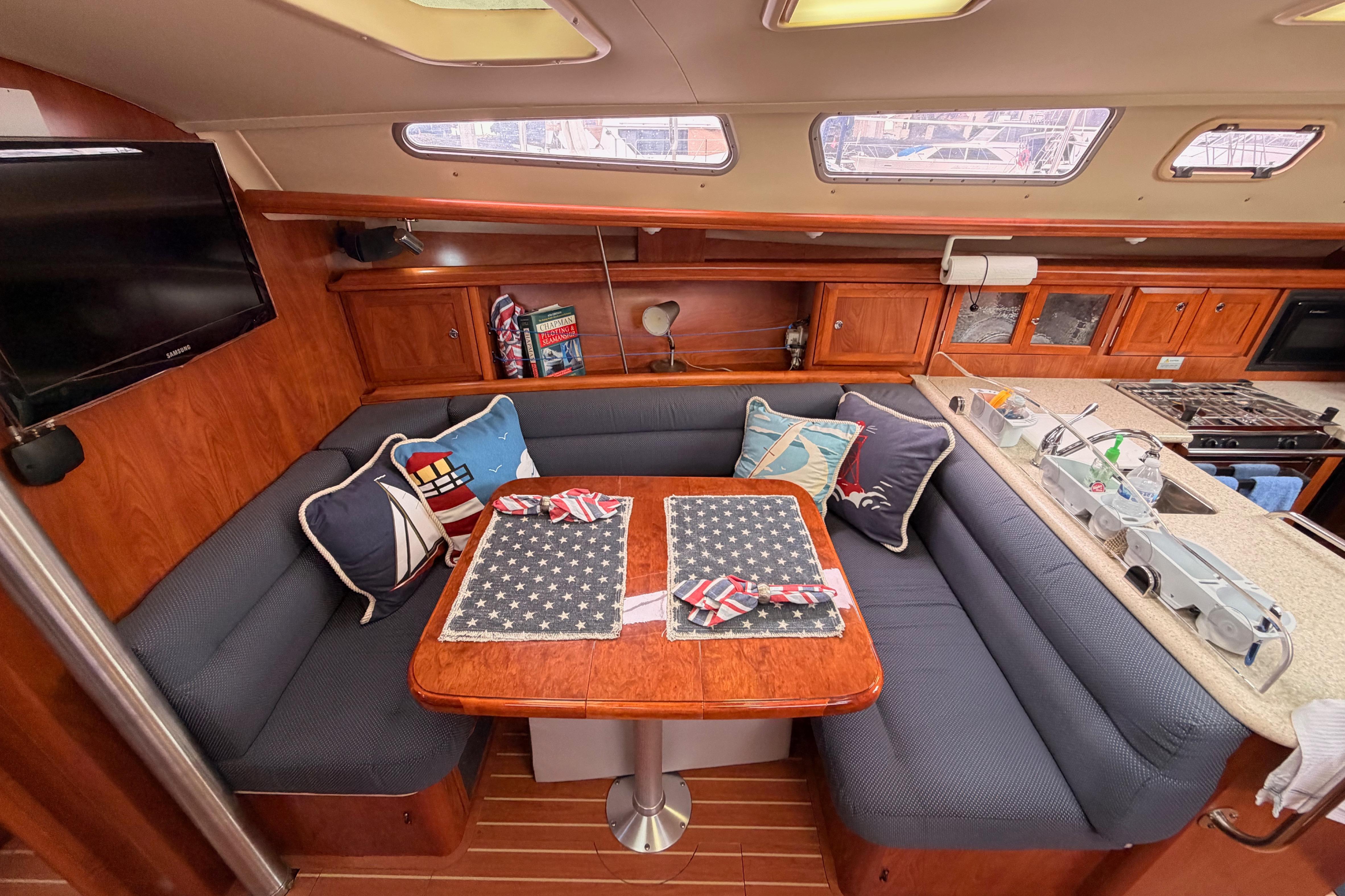 Cozy interior of 2009 Hunter 38 sailboat with dining area and kitchen.
