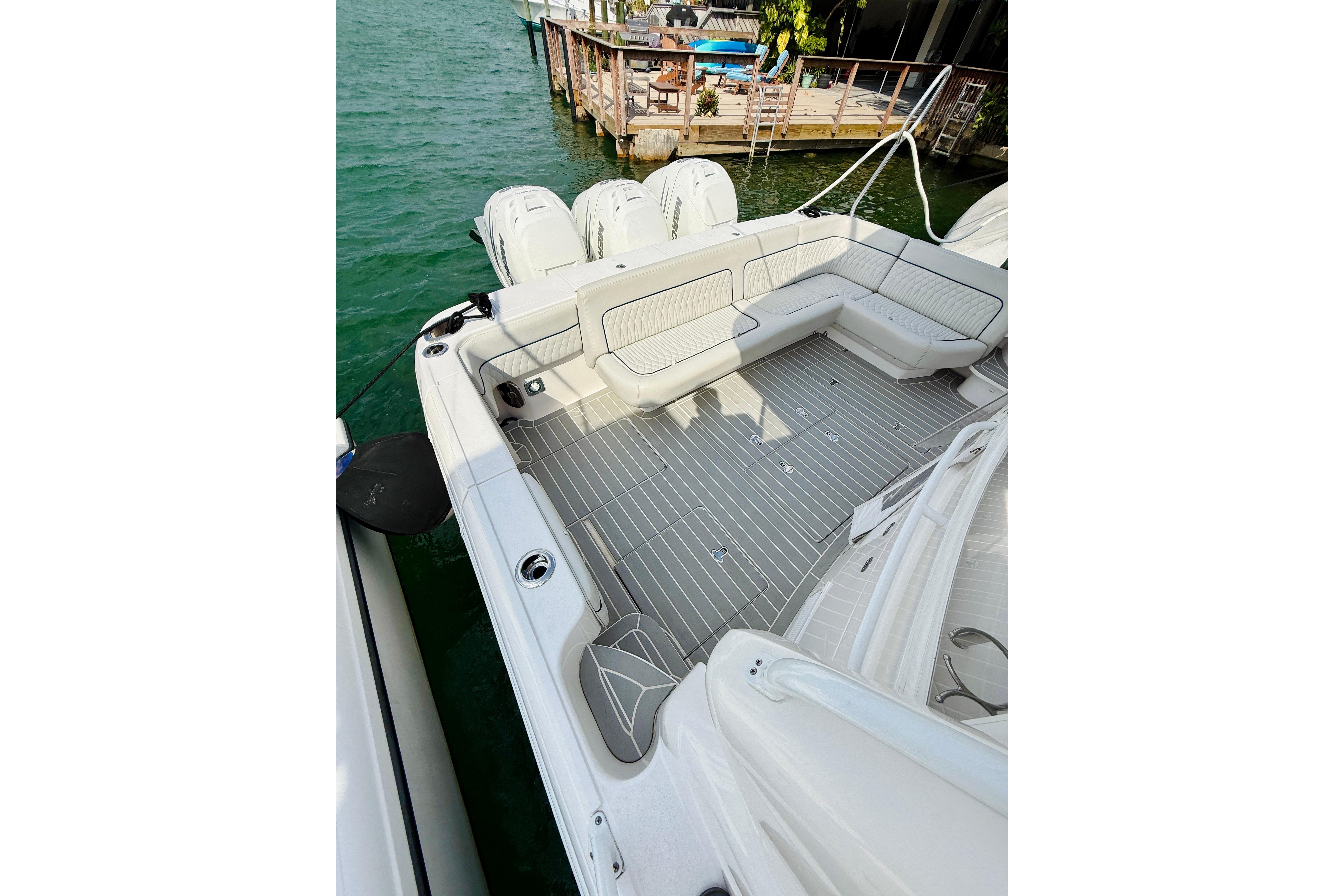 2021 Intrepid 410 Evolution boat deck with seating, docked by clear water.