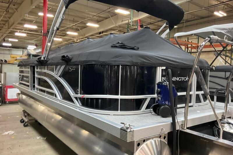 2026 Bennington 22 SSRSF pontoon boat with black cover in a warehouse setting.