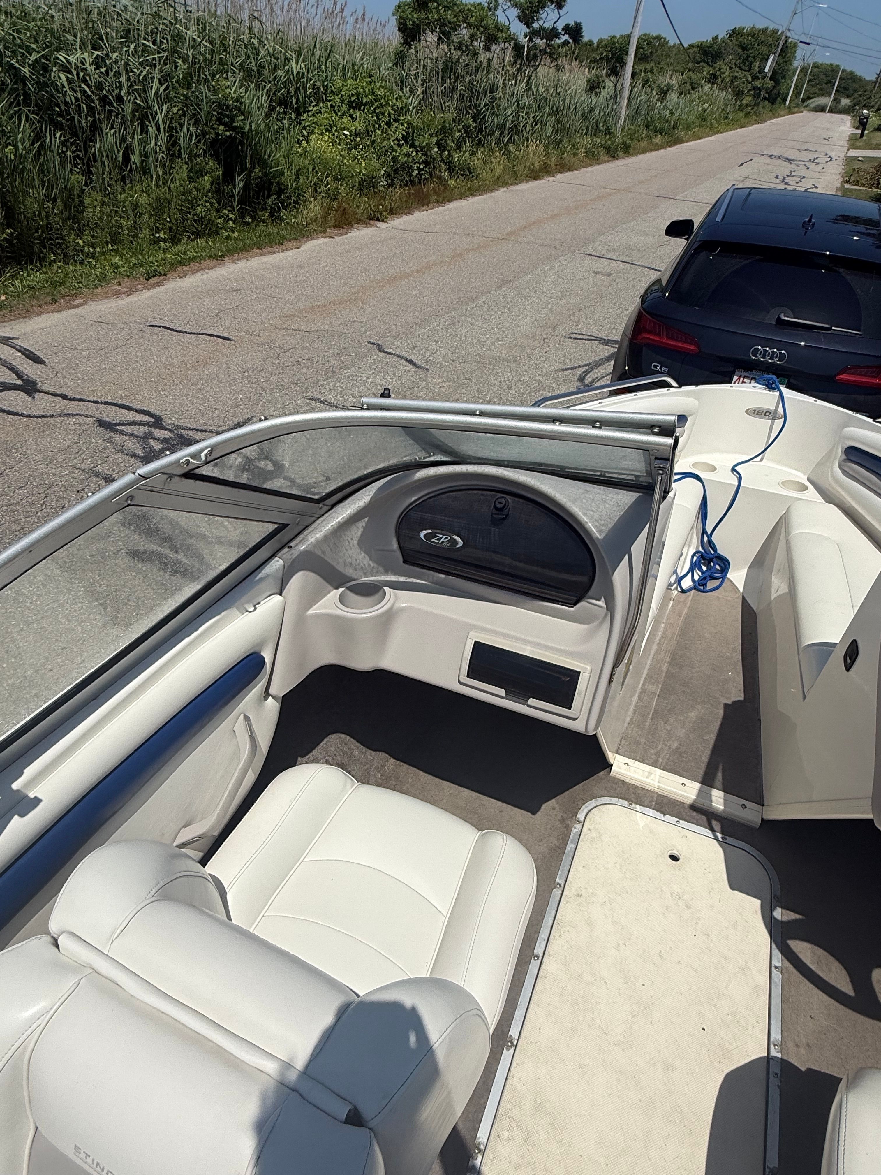 The image shows the cockpit of a 2003 Stingray 180 LS/LX boat with white seating.