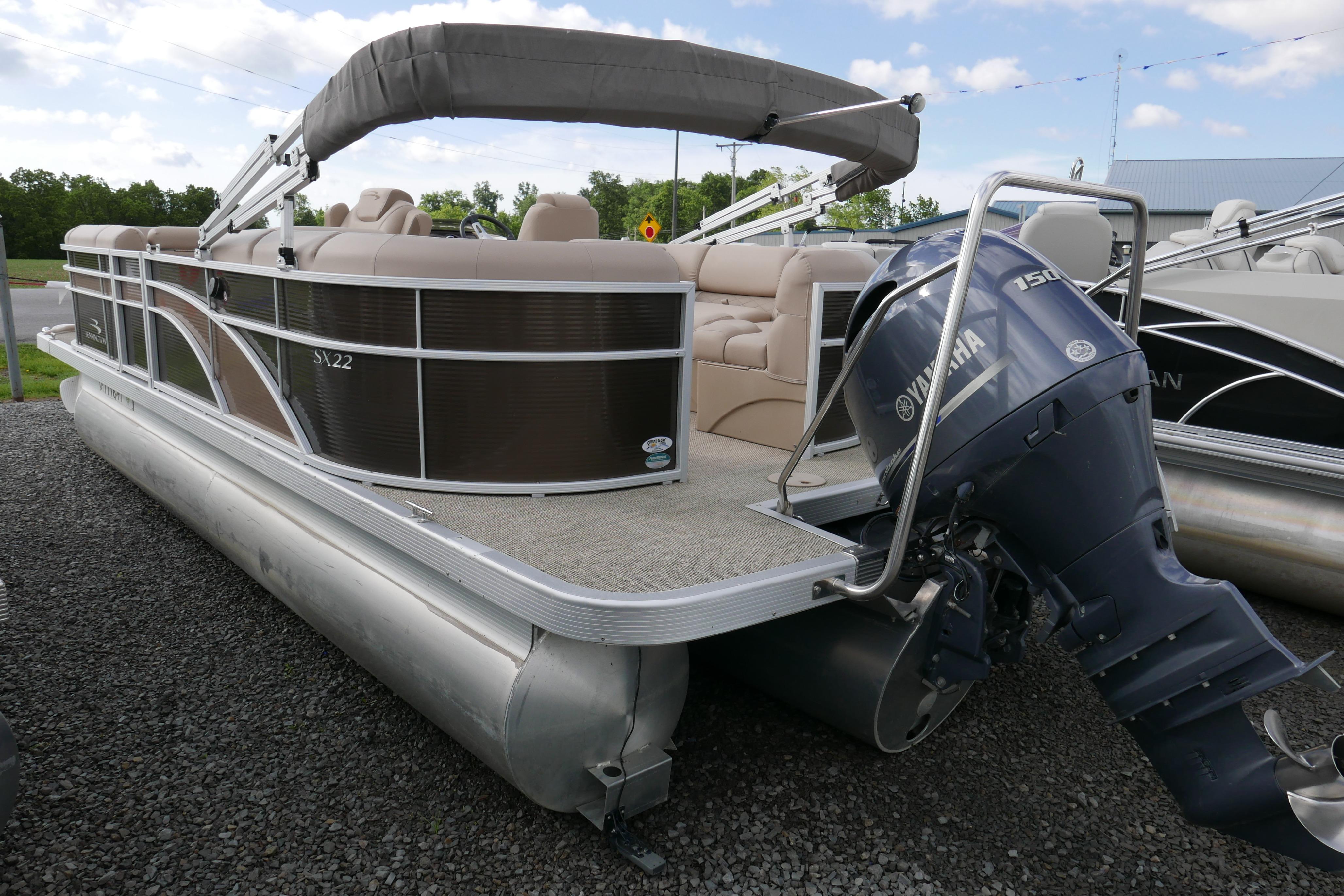 2018 Bennington 22 SSRX pontoon boat with Yamaha outboard motor, parked on gravel.