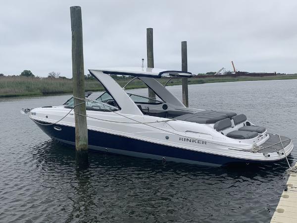 2020 Rinker 29QX BR boat docked on a calm waterway.