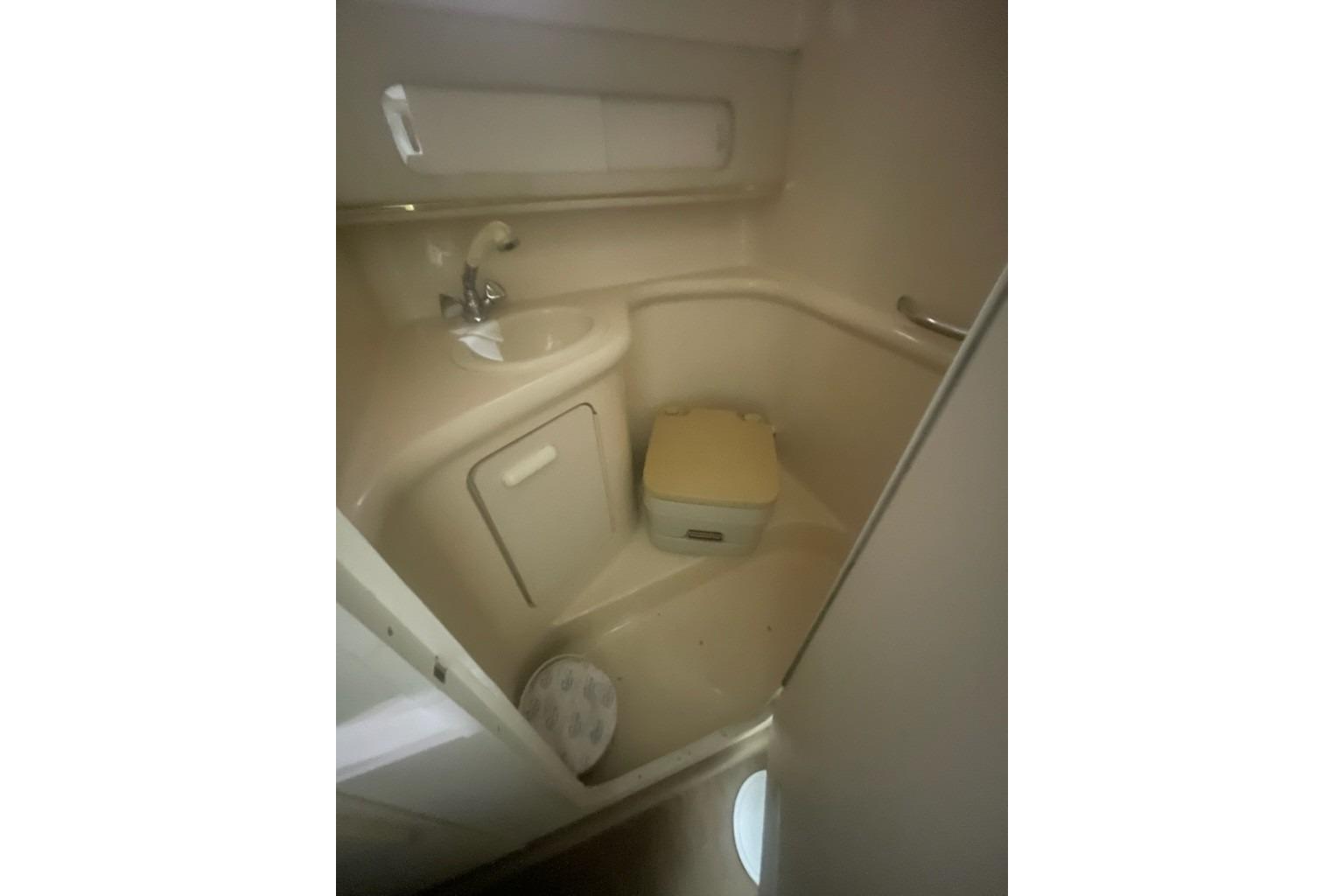 1998 Sea Ray 270 Sundancer bathroom with sink, toilet, and storage cabinet.