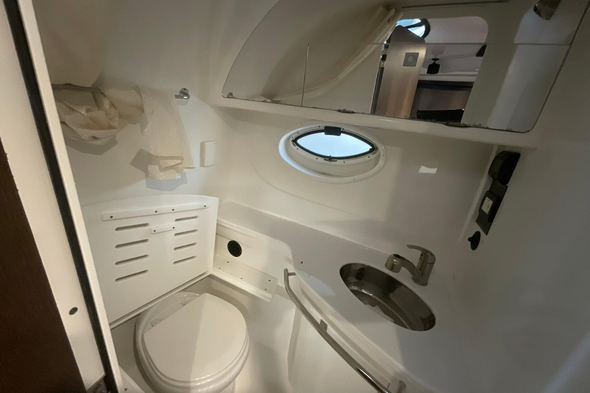 2019 Monterey 335 Sport Yacht bathroom with toilet, sink, and porthole window.