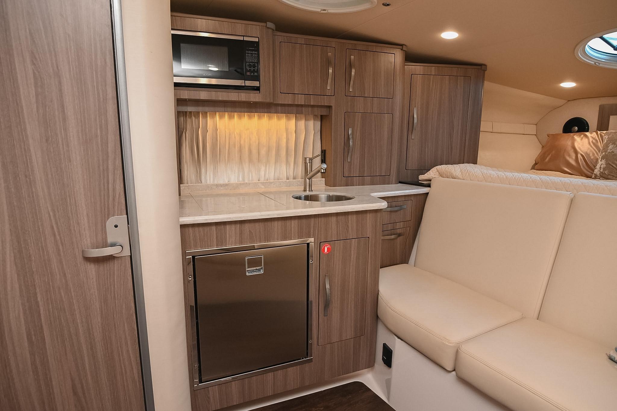 2021 Regal 33 Express yacht interior with kitchenette, microwave, and seating area.